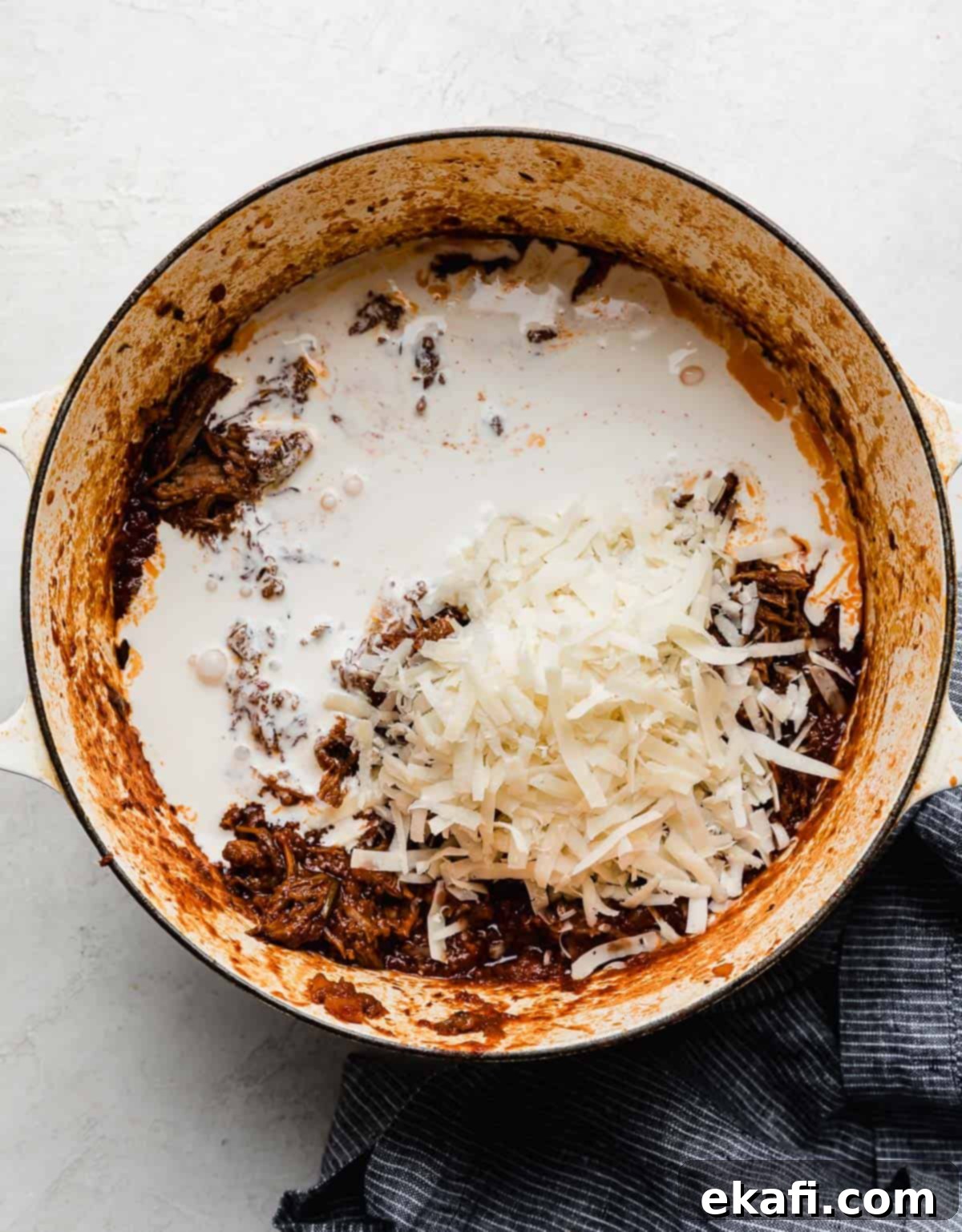 Hearty Shredded Beef Ragu 12 Heavy cream and parmesan cheese a top beef Ragu in a large pot.