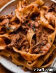 Hearty Shredded Beef Ragu 17 Shredded beef Ragu with pappardelle pasta on a white plate.