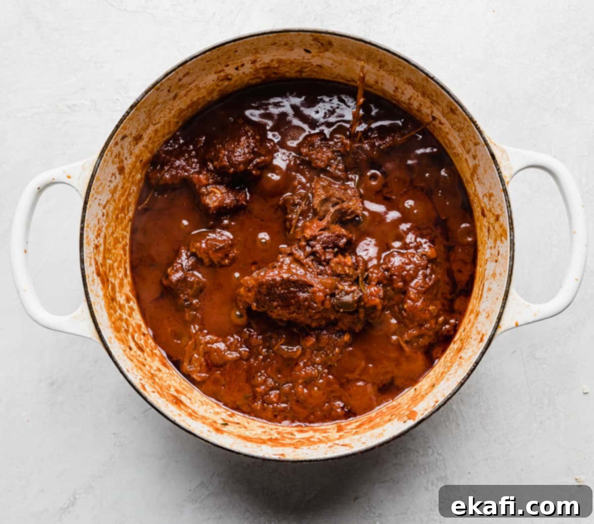 Hearty Shredded Beef Ragu 8 Beef Ragu in a white pot on a white background.