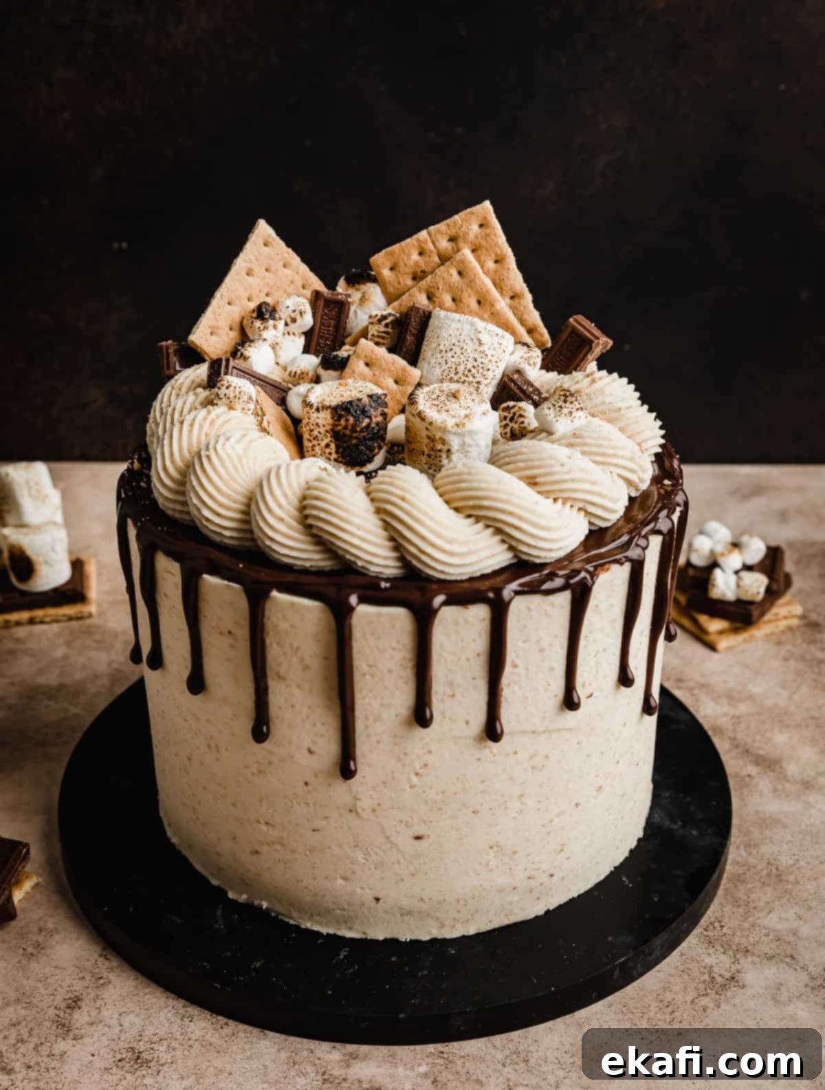 S'mores Cake 2 Delicious layered s'mores cake with a chocolate drip topped with graham cracker squares, toasted marshmallows and chocolate squares.