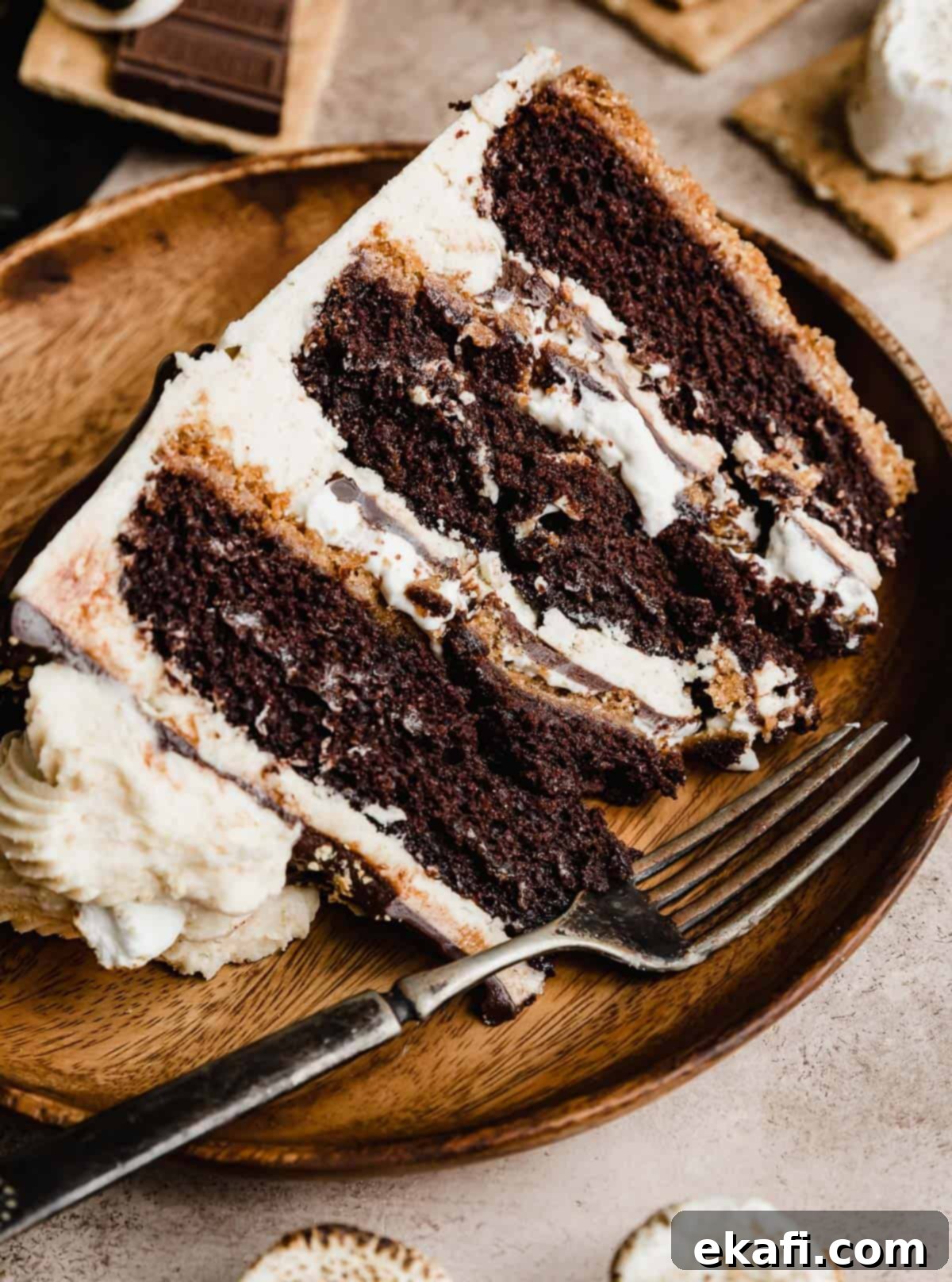 S'mores Cake 13 A s'mores cake slice on a brown plate with a fork next to the cake.