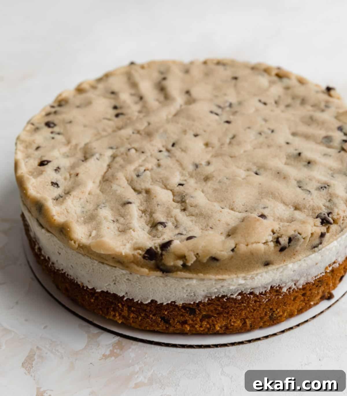 The Ultimate Cookie Dough Dream Cake 6 A layer of edible cookie dough placed on top of a frosted cake layer, ready for the next cake layer.