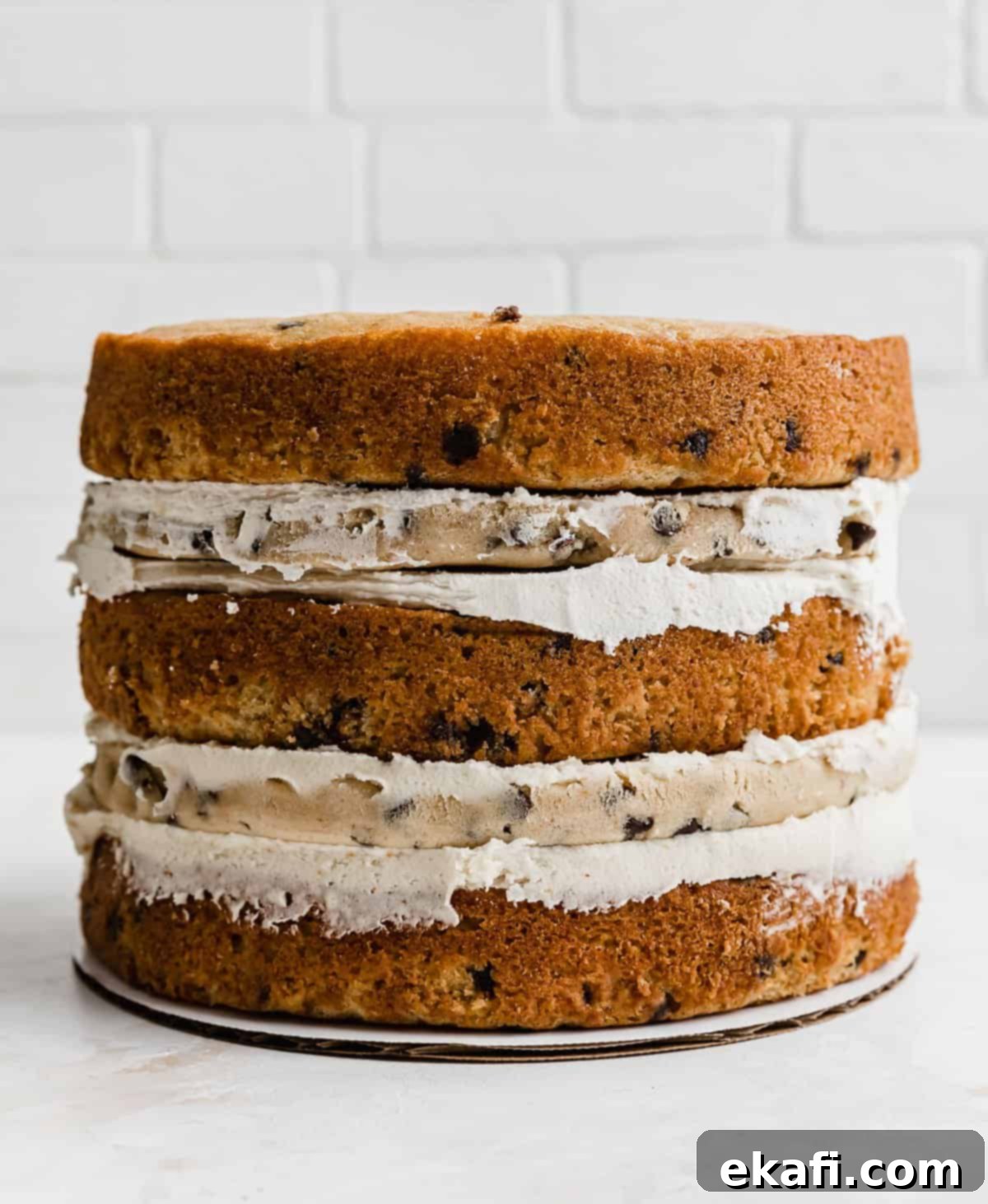 The Ultimate Cookie Dough Dream Cake 7 A three-tier Brown Butter Cookie Dough Cake, fully assembled but not yet frosted with the final layer of buttercream, showing its naked layers.