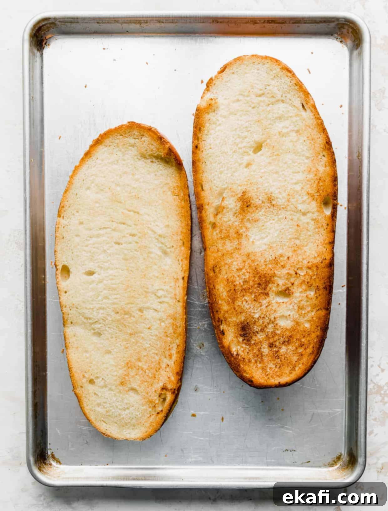 French Bread Pizza 6 Golden toasted French bread loaf on a baking sheet.
