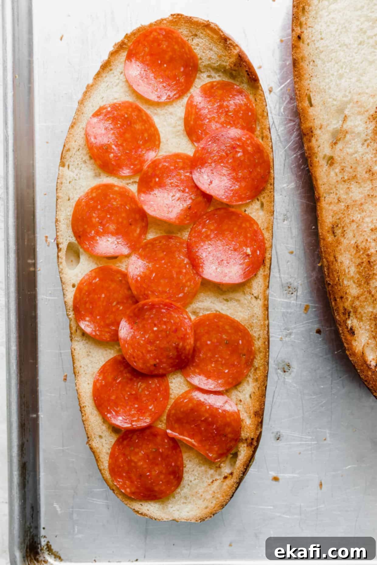 French Bread Pizza 7 A loaf of French bread topped with sliced pepperonis.