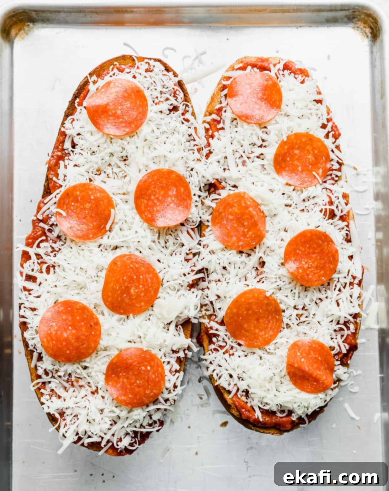 French Bread Pizza 10 Mozzarella and pepperonis overtop of French bread loaf halves.