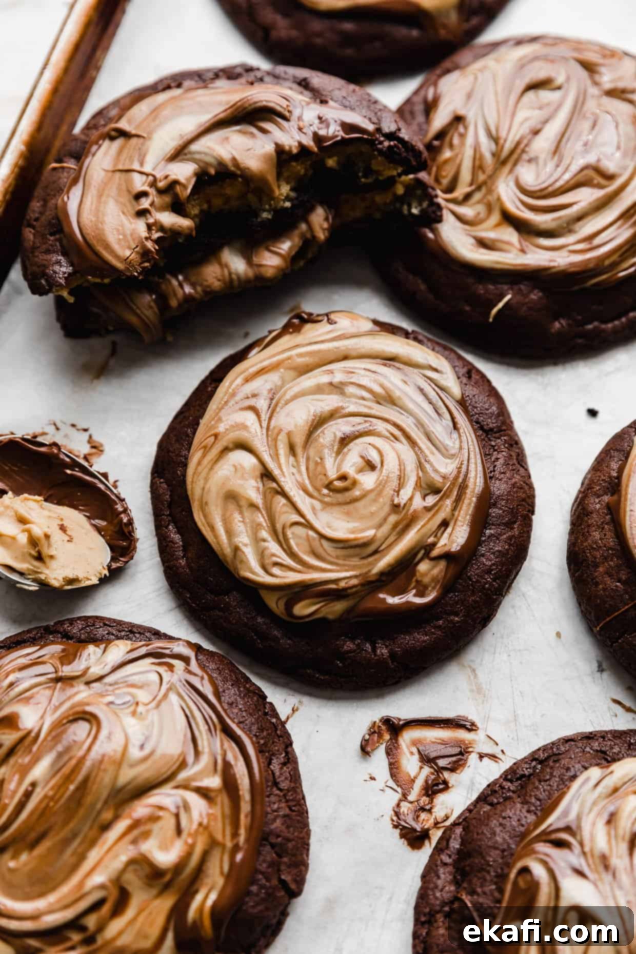 Μπισκότα με φυστικοβούτυρο και καφέ brownie Crumbl 2 Σοκολάτα και φυστικοβούτυρο ανακατεμένα πάνω από ένα μπισκότο μπράουνι.