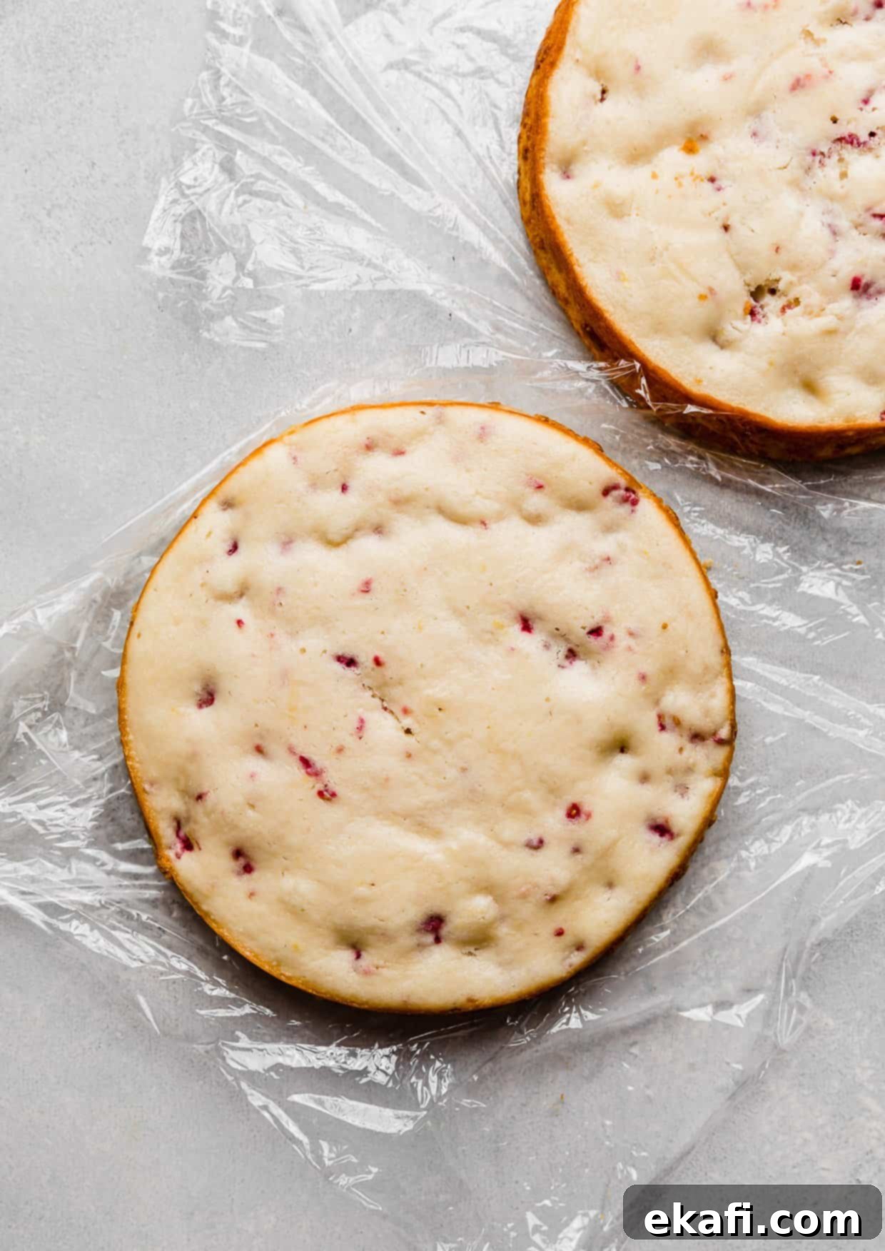 Perfect Lemon Raspberry Cake 4 A Lemon Raspberry round cake layer on a piece of plastic wrap.