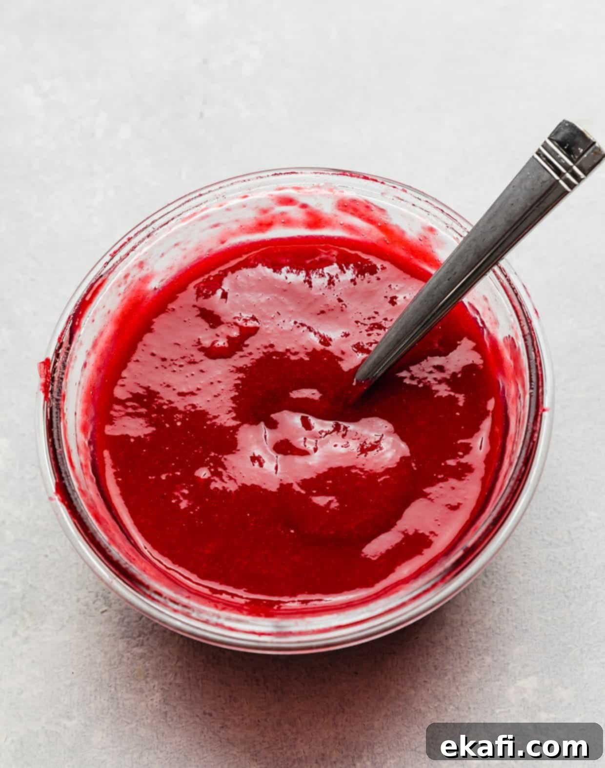 Perfect Lemon Raspberry Cake 5 A glass bowl with a homemade raspberry sauce in it.