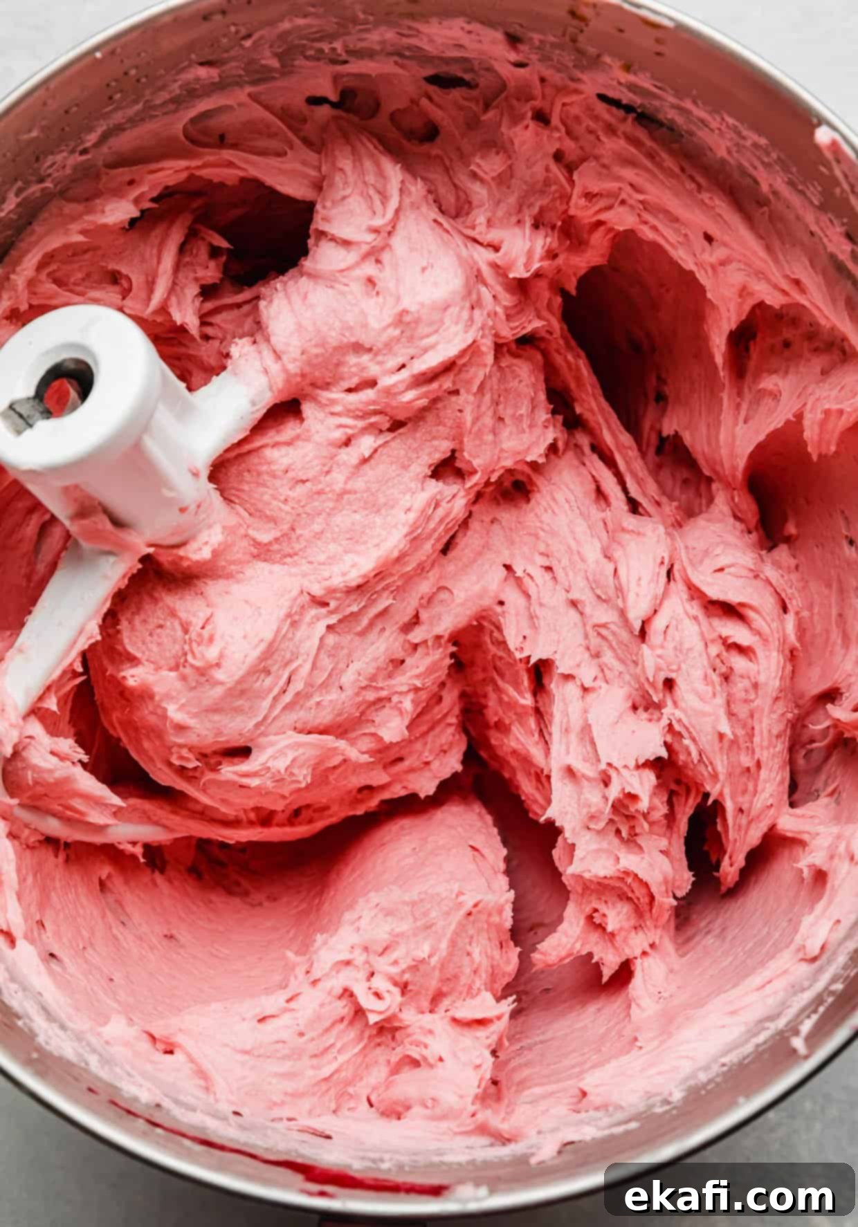 Perfect Lemon Raspberry Cake 6 A pink colored raspberry buttercream in a metal mixing bowl.