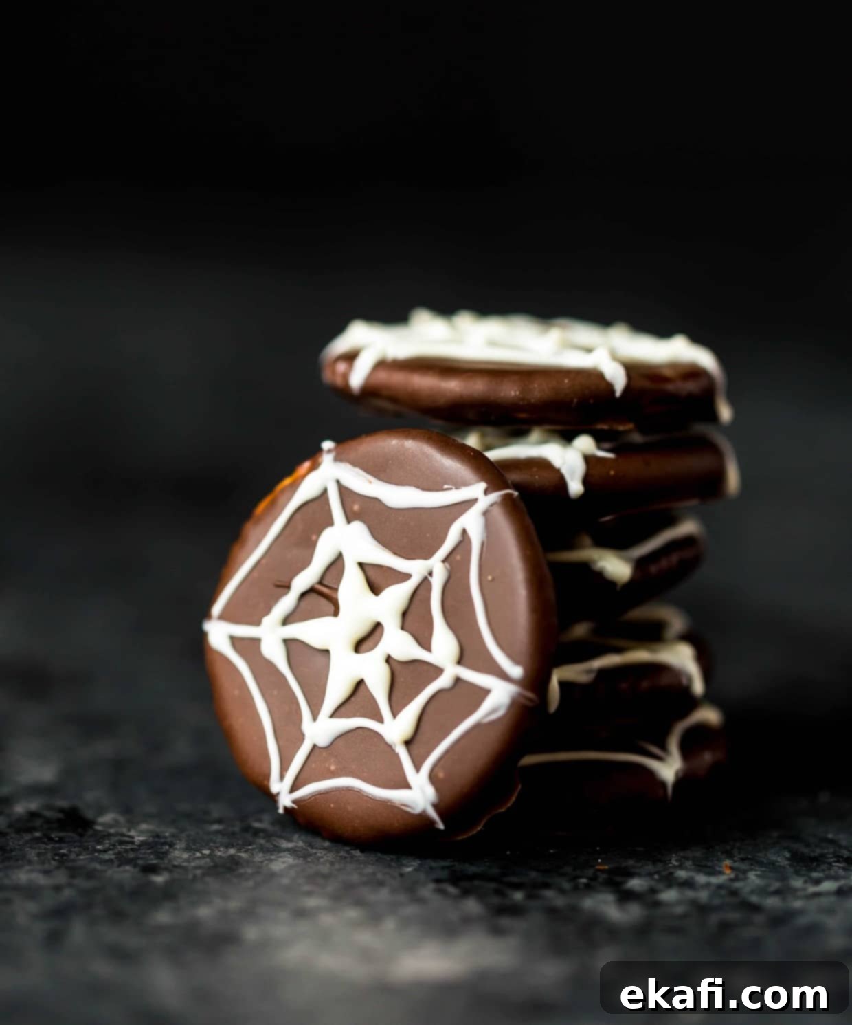 Haunted Snaps 9 Chocolate covered ritz crackers featuring a white chocolate spider web design on top of cracker, close up.