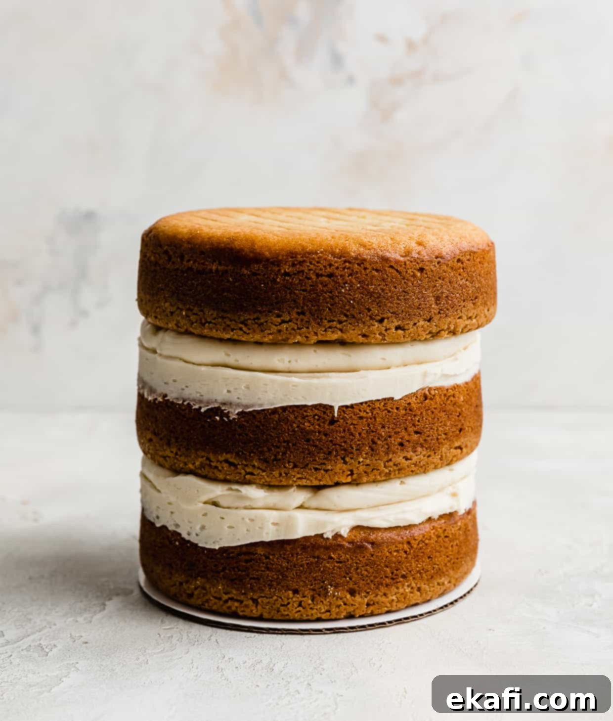 Golden Oreo Dream Cake 11 Three Golden Oreo cake layers stacked on top of each other against a white background.