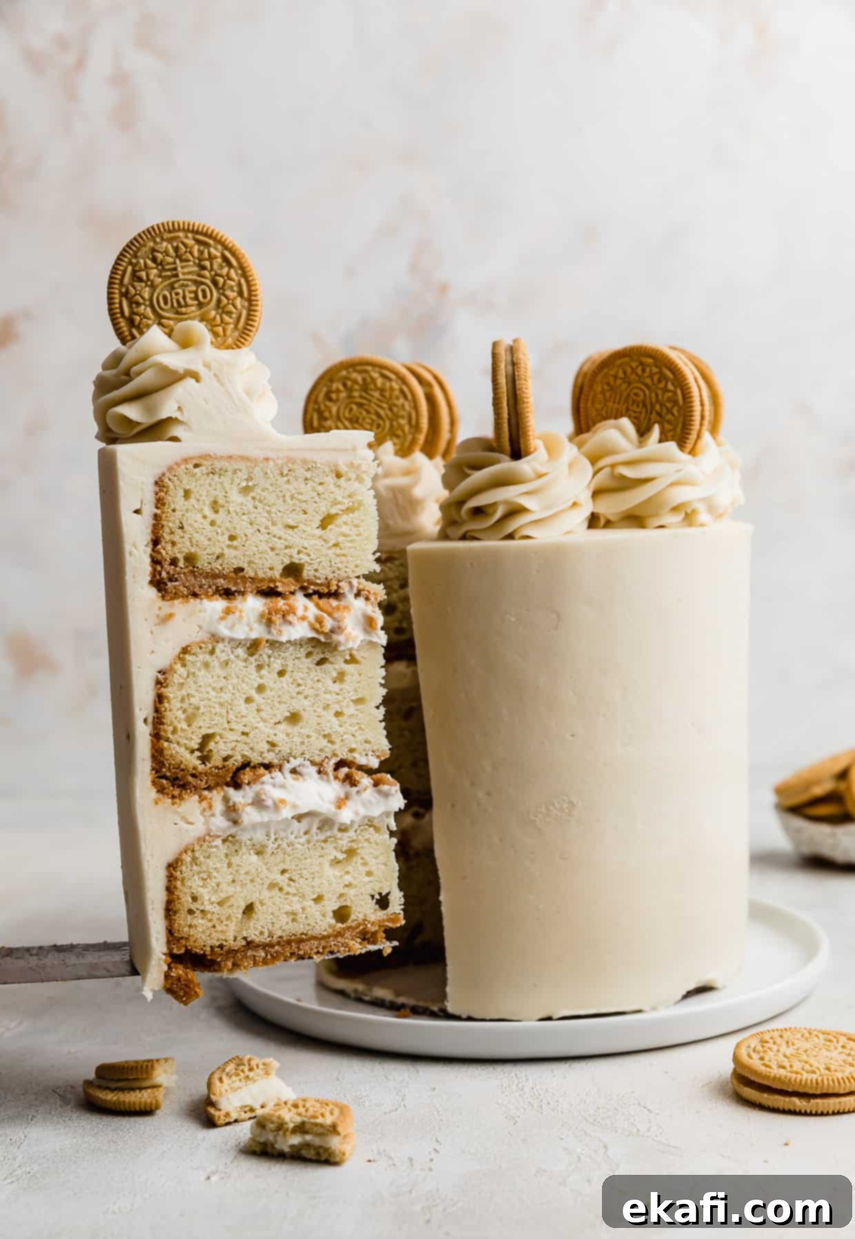 Golden Oreo Dream Cake 13 A slice of Golden Oreo Cake balancing on a knife infant of a decorated Golden Oreo Cake.