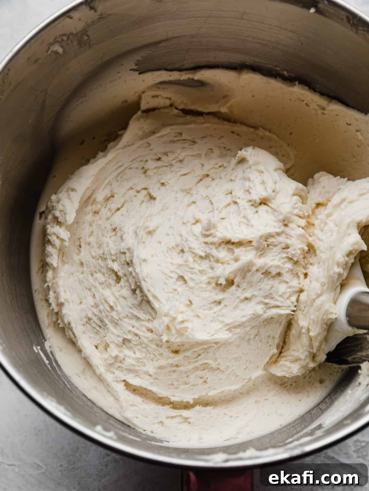 Golden Oreo Dream Cake 7 A white buttercream frosting with crushed Golden Oreo's mixed into it, in a silver bowl.
