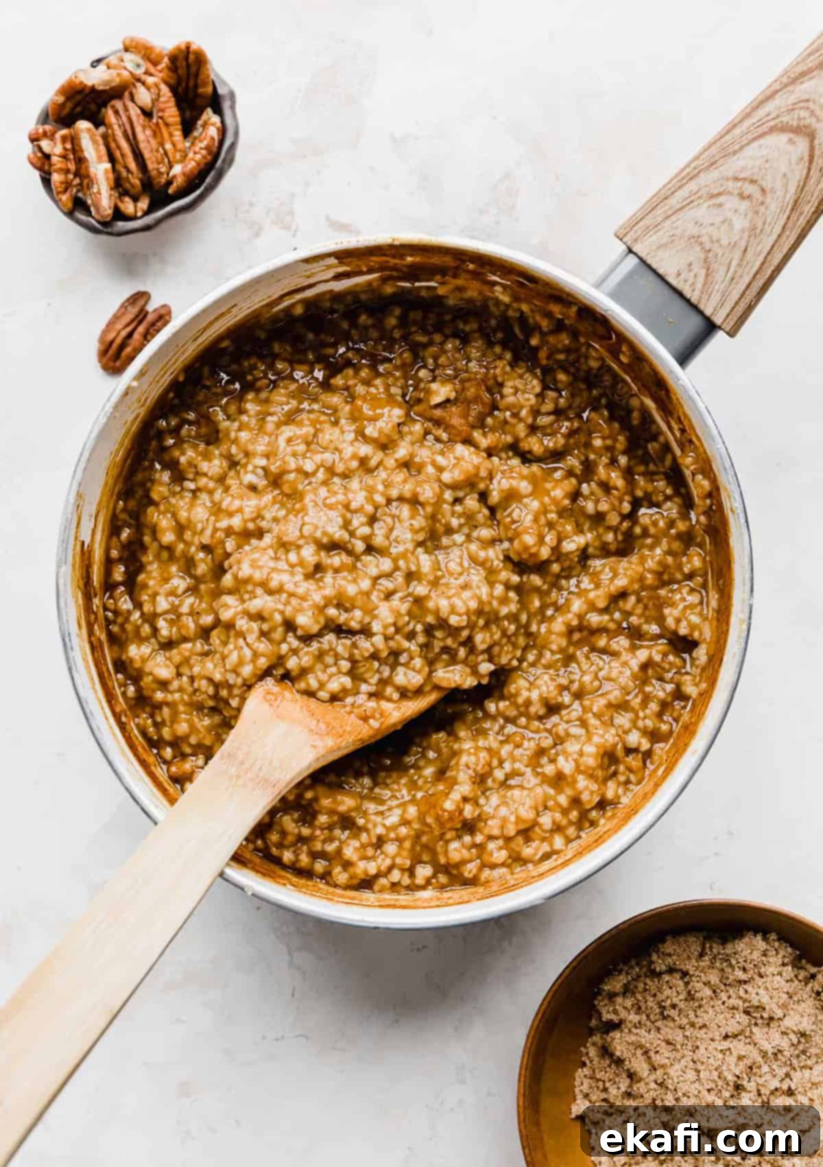 Autumn Pumpkin Spice Steel Cut Oats 7 A wooden spoon actively stirring a creamy batch of Pumpkin Steel Cut Oats in a saucepan, showcasing the delicious texture and warmth of the breakfast.