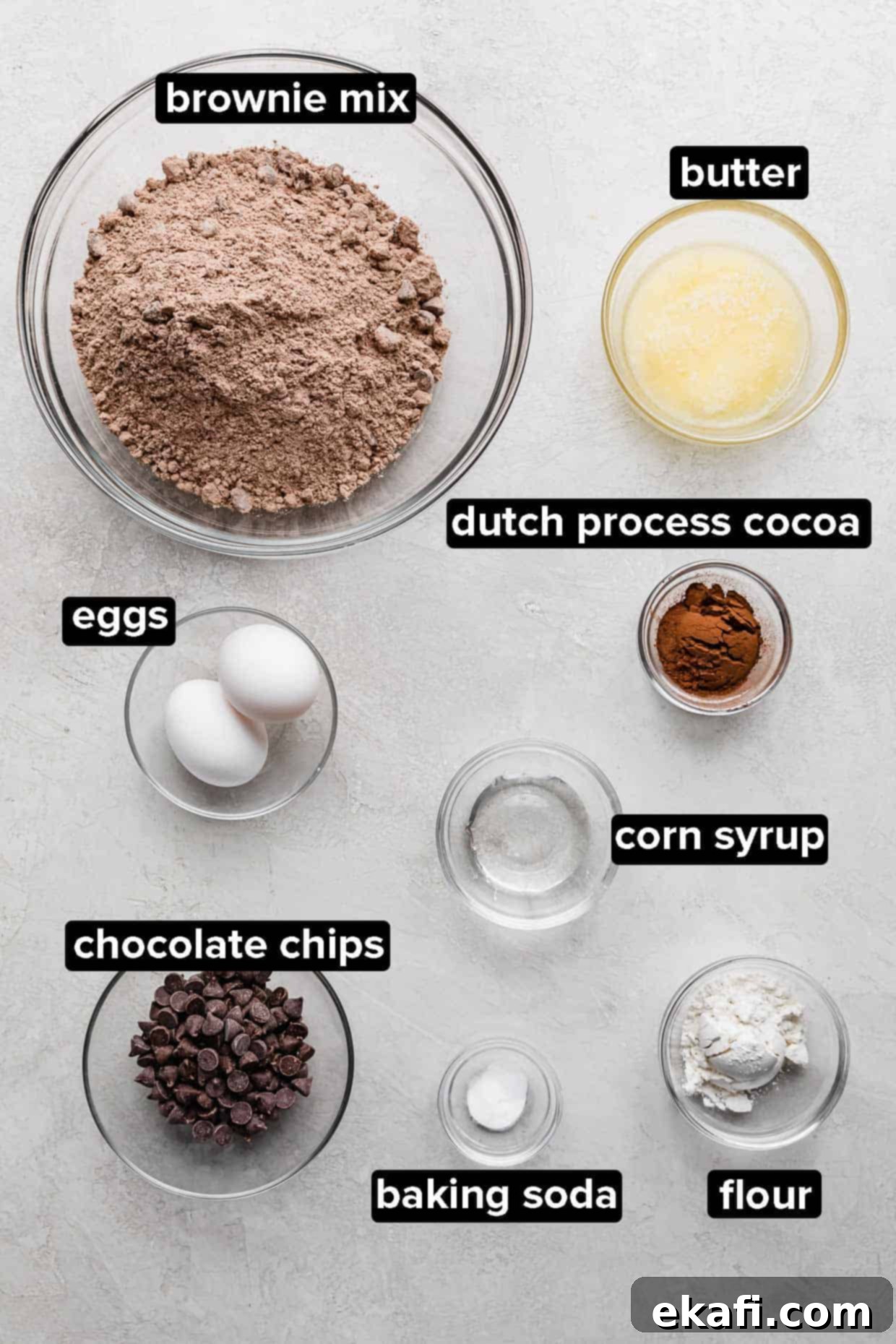 Crumbl's Signature Brownie Batter Cookies 3 Brownie batter cookie ingredients portioned into glass bowls on a light gray background.