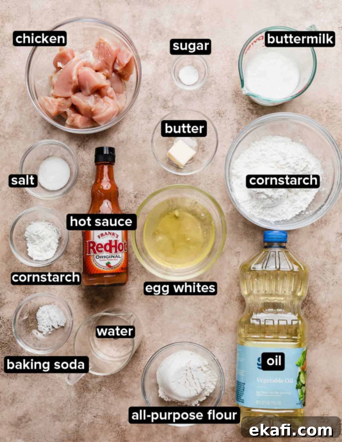Fiery Buffalo Chicken Poppers 3 Buffalo Chicken Bites ingredients portioned into glass bowls on a light beige background, including chicken, buttermilk, flour, and cornstarch.