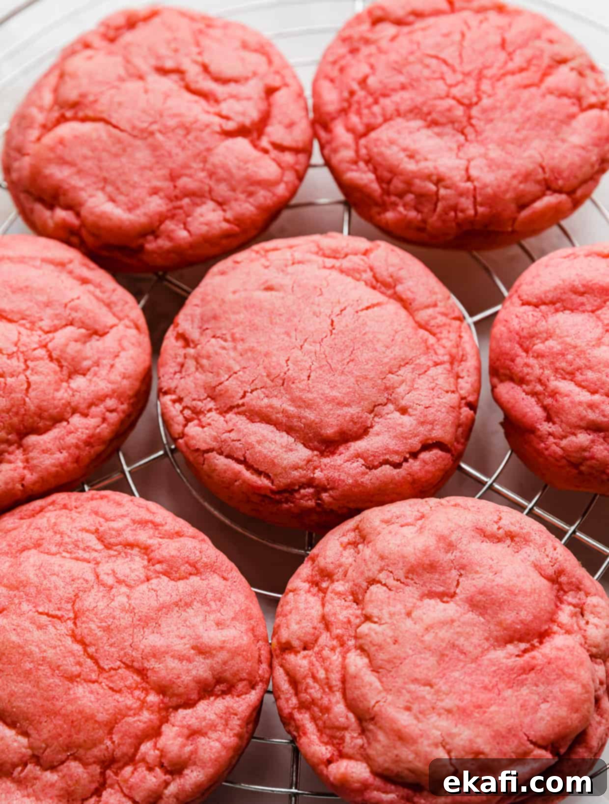 Blush Velvet Crumbl Delights 9 Crumbl Pink Velvet Cookies without frosting, on a wire cooling rack.