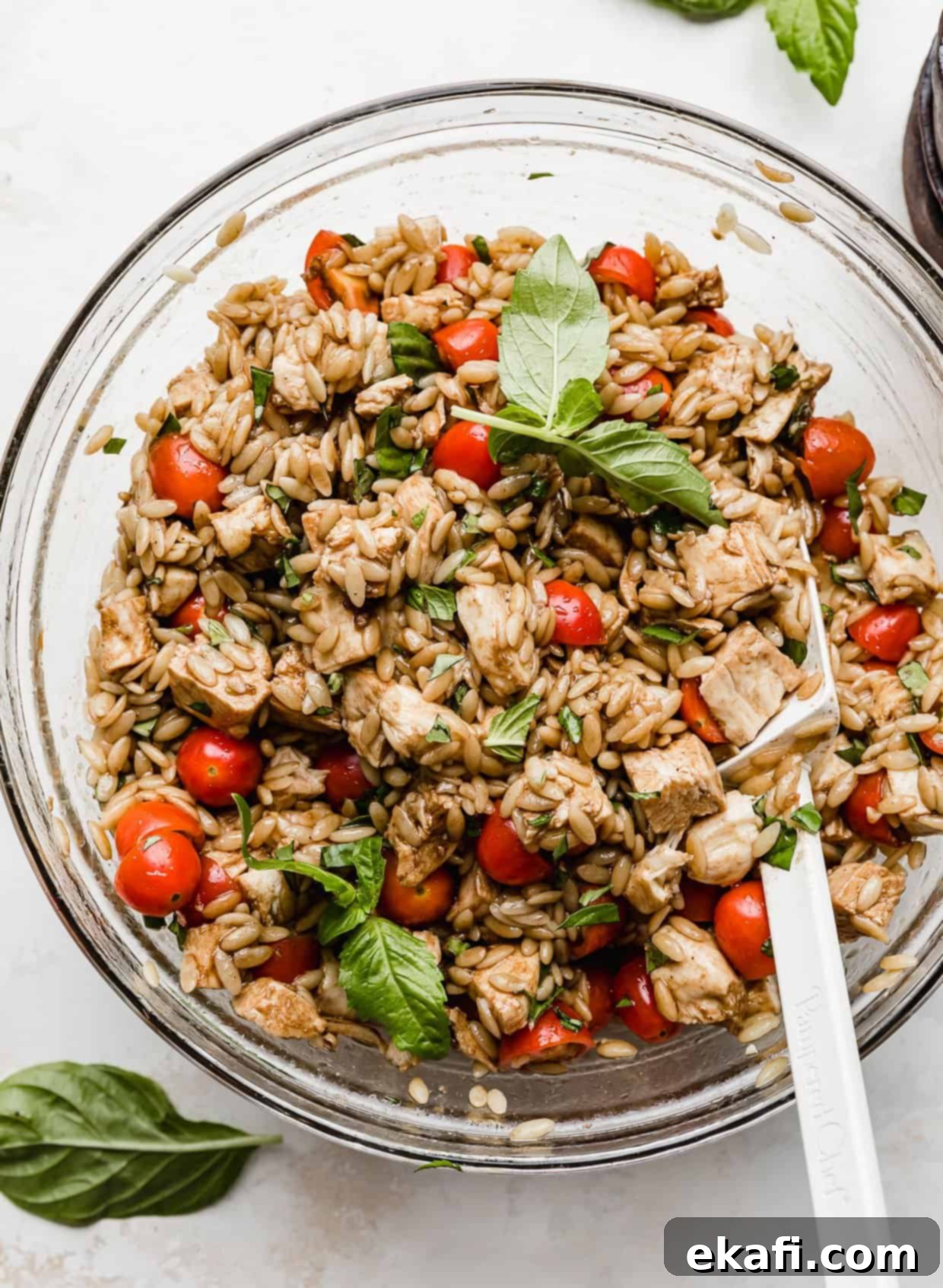 Perfect Summer Caprese Orzo 2 Caprese Orzo Salad in a glass bowl with fresh basil garnish.