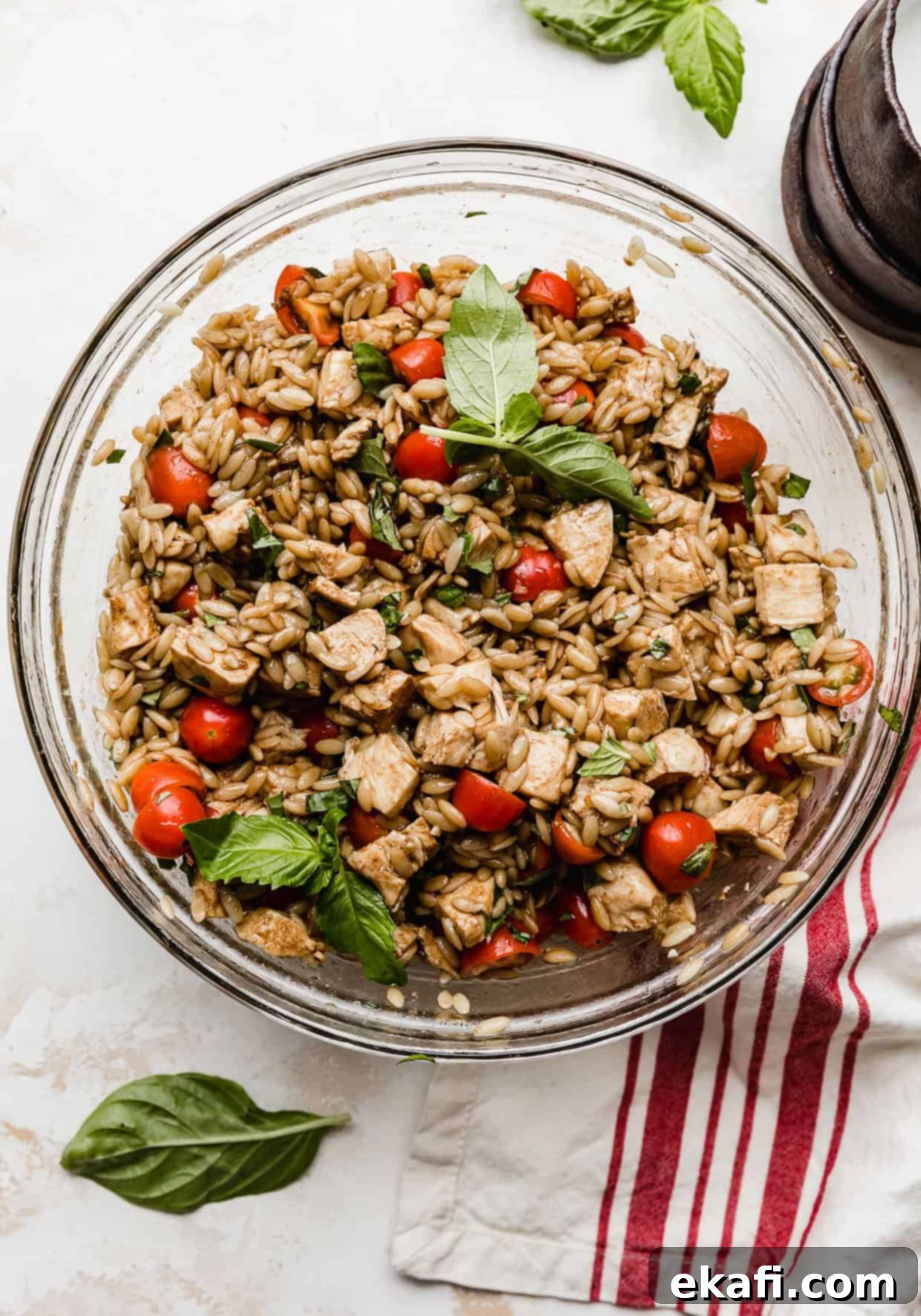Perfect Summer Caprese Orzo 9 A chicken Caprese Orzo Salad in a glass bowl with a balsamic dressing.