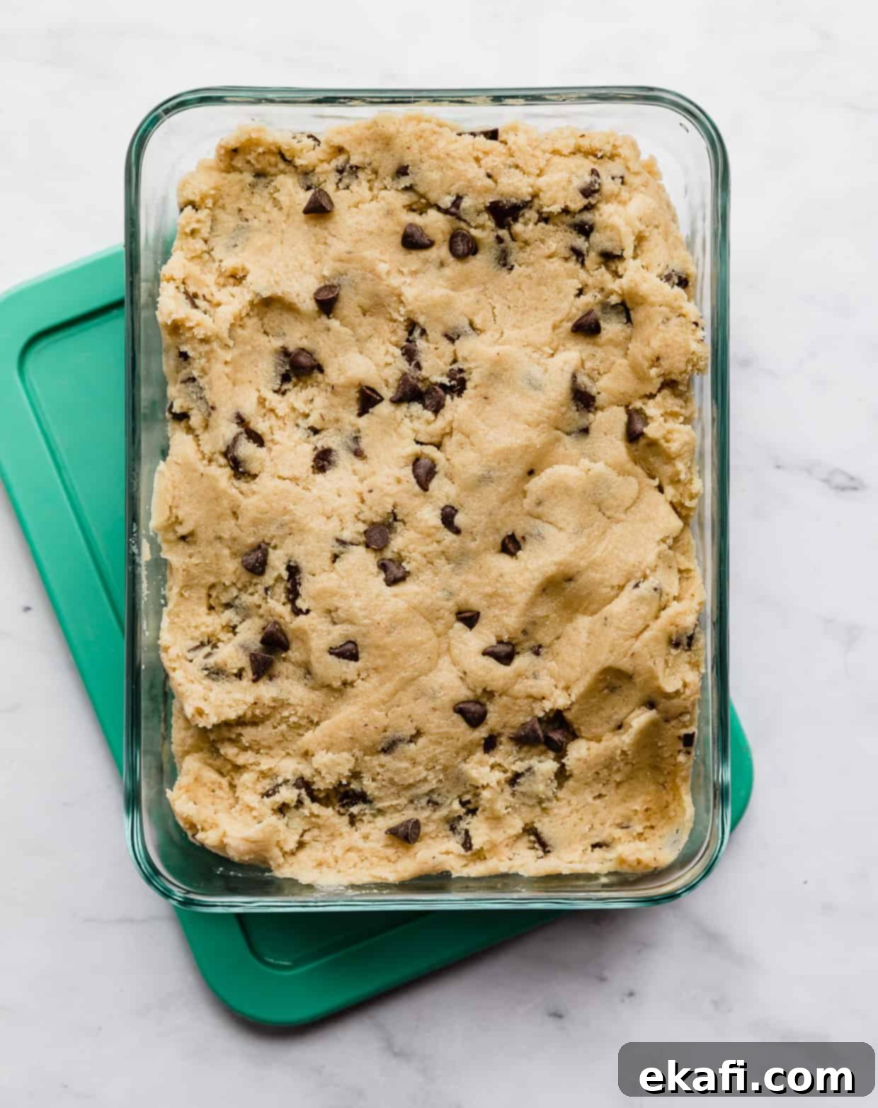 Freeze Cookie Dough for Instant Treats 3 Chocolate chip cookie dough in a rectangle glass storage container.