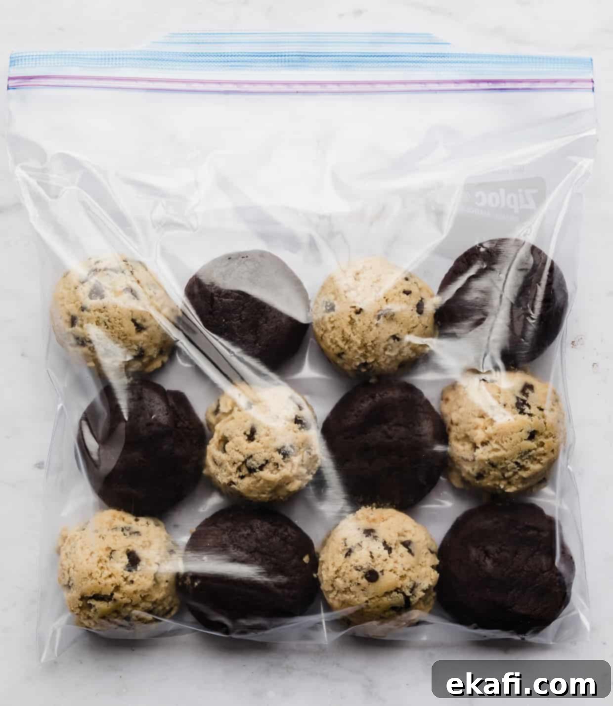 Freeze Cookie Dough for Instant Treats 6 A ziplock bag with frozen chocolate chip cookie dough balls and frozen brownie batter balls in it.