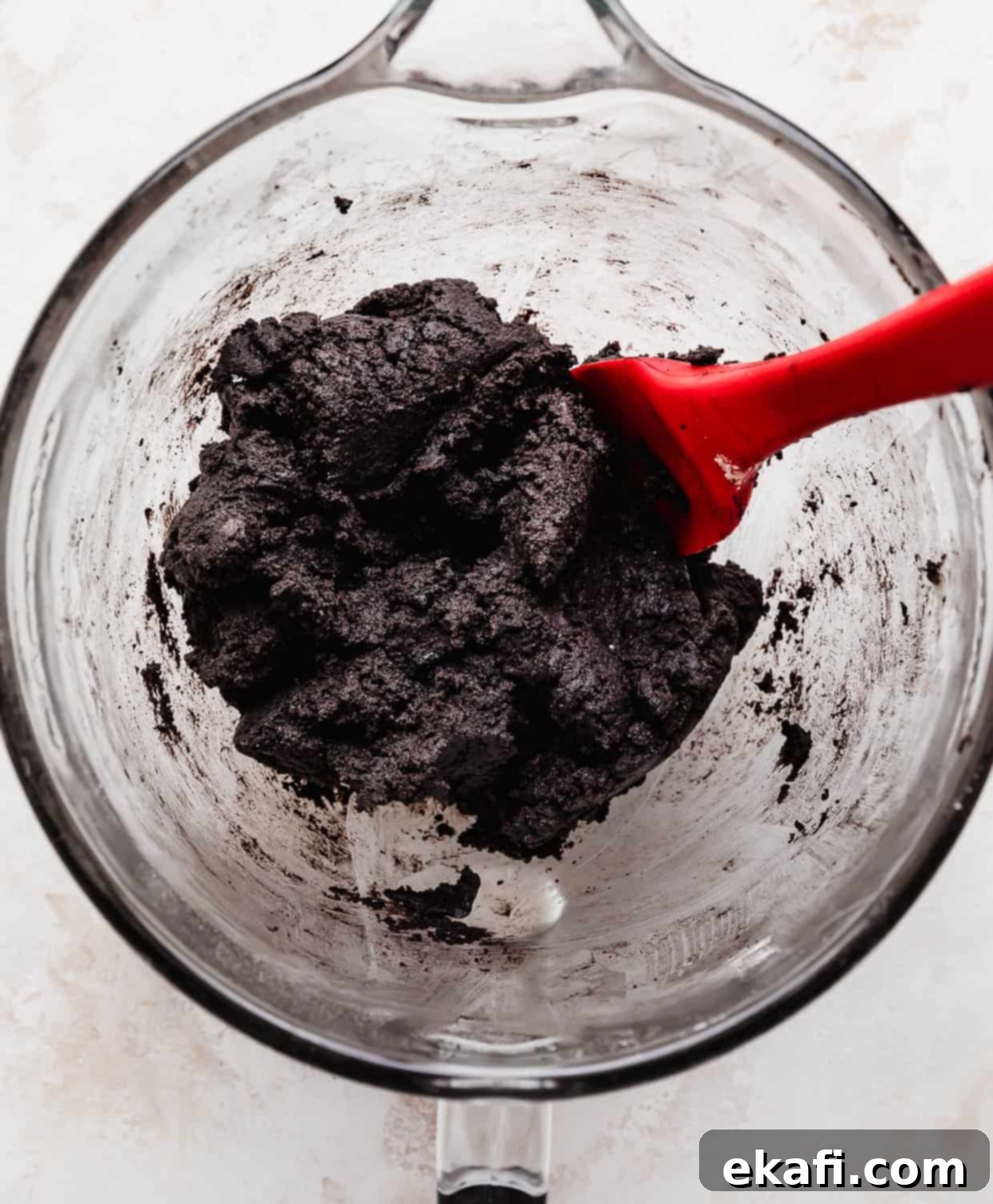 Crumbl Oreo Birthday Cake Cookie Delight 5 Oreo Birthday Cake Cookie dough in a glass mixing bowl on a white background.
