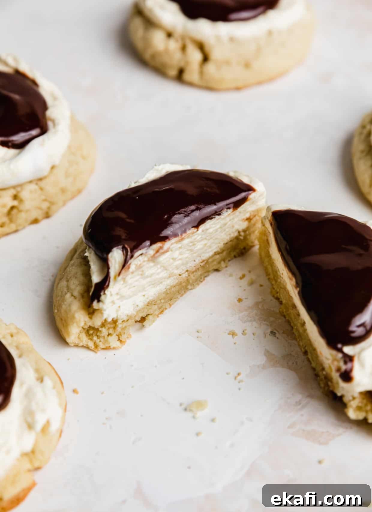 Μπισκότα Πάστα Βοστώνης 3 Ένα μπισκότο Boston Cream Pie Cookie, αντιγραφής Crumbl, κομμένο στη μέση, σε λευκό φόντο.