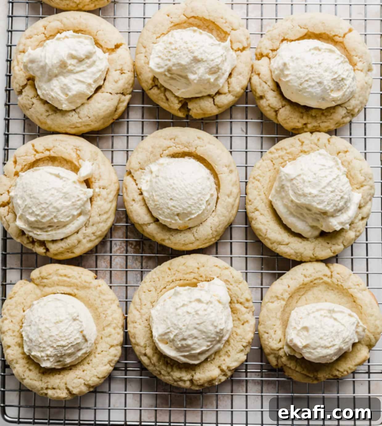 Μπισκότα Πάστα Βοστώνης 10 Crumbl Boston Cream Pie Cookies με μια κουταλιά ανοιχτοκίτρινης κρέμας πουτίγκας βανίλιας στο κέντρο κάθε μπισκότου.