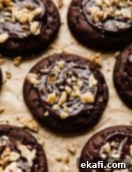 Fudgy Walnut Cookie Brownies 9 A chocolate brownie cookie topped with a melted chocolate ganache and chopped walnuts.