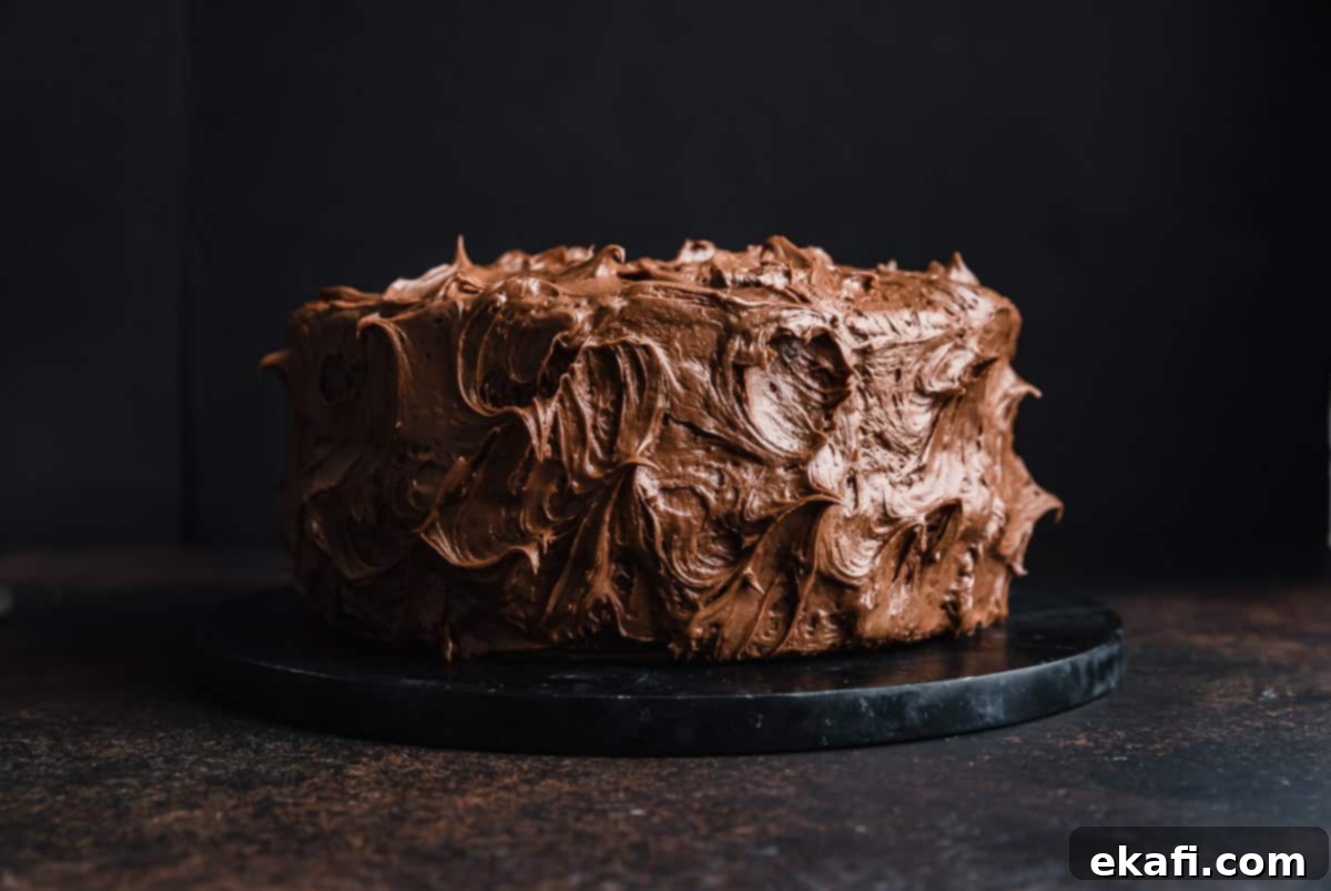 Velvet Chocolate Cream Cheese Cake 8 A two layer chocolate cake on a black cake plate against a black background.