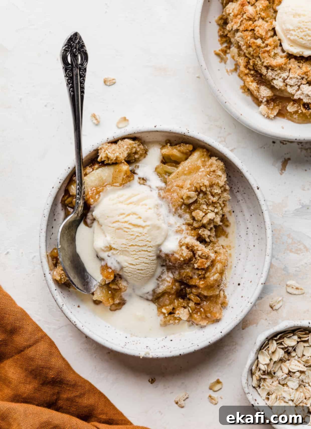 Quick & Easy Apple Crisp 2 A white plate with ice cream topped apple crisp on it.