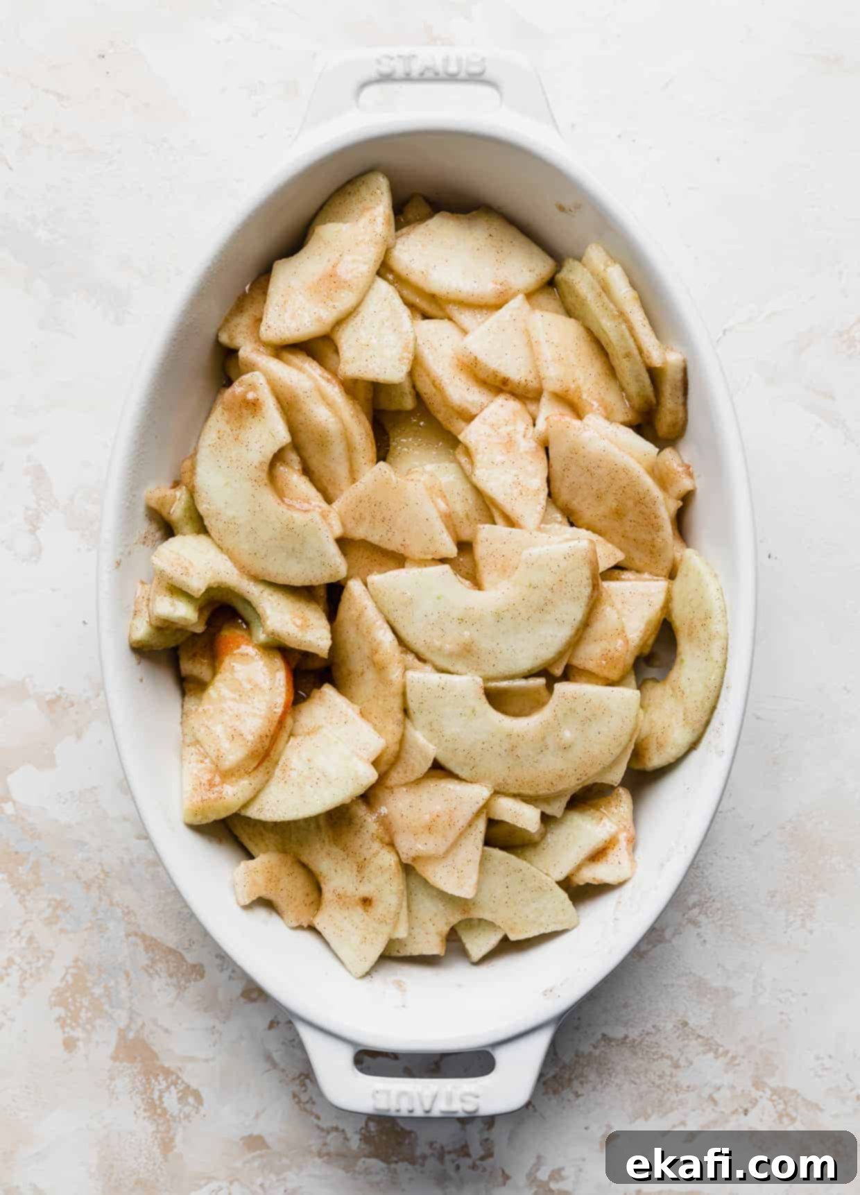Quick & Easy Apple Crisp 6 Cinnamon sugar topped sliced apples in an oval white baking dish.