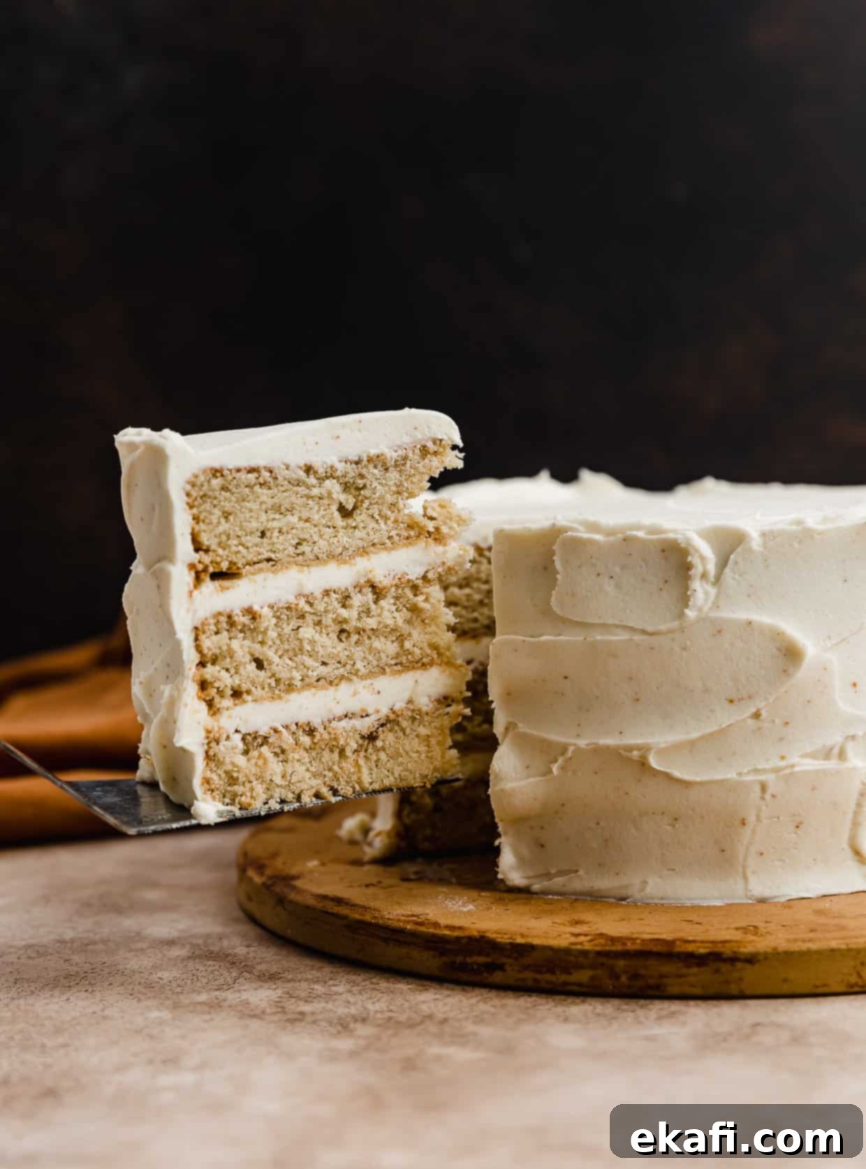 Toasted Butter Bliss 2 A three layered Brown Butter Cake with a slice of cake cut and balancing on a knife.