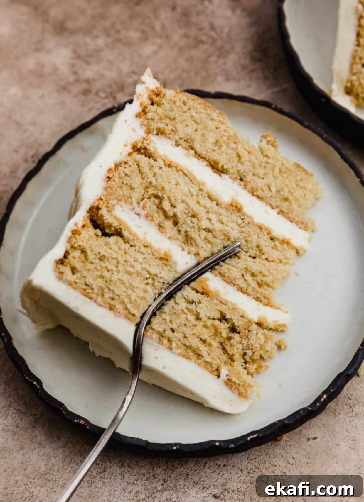 Toasted Butter Bliss 9 A slice of brown butter layer cake frosted with brown butter buttercream on a white plate.