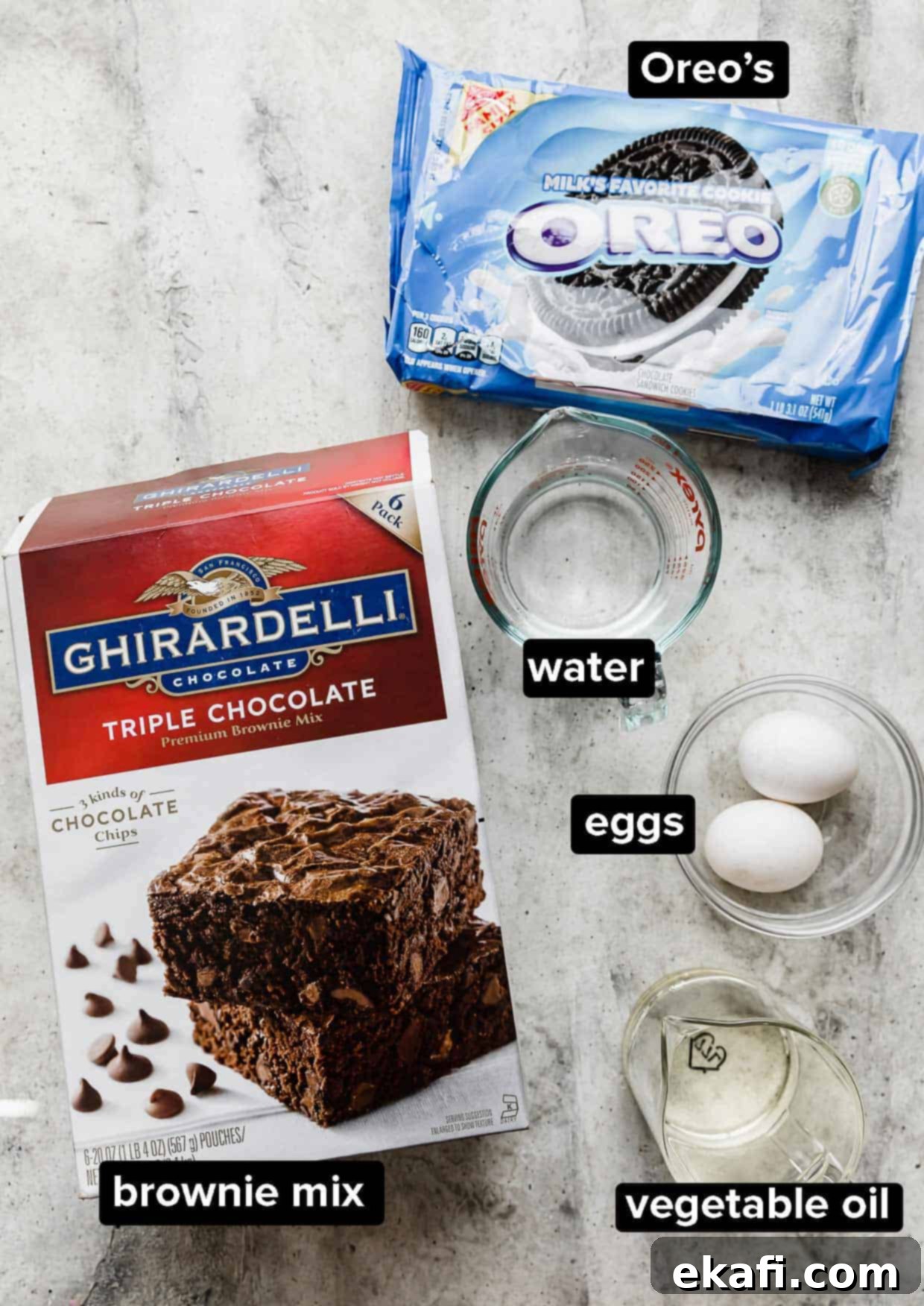 Ultimate Oreo Fudge Brownies 3 Ingredients used to make Oreo brownies on a gray background: boxed brownie mix, Oreos, water, eggs, vegetable oil.
