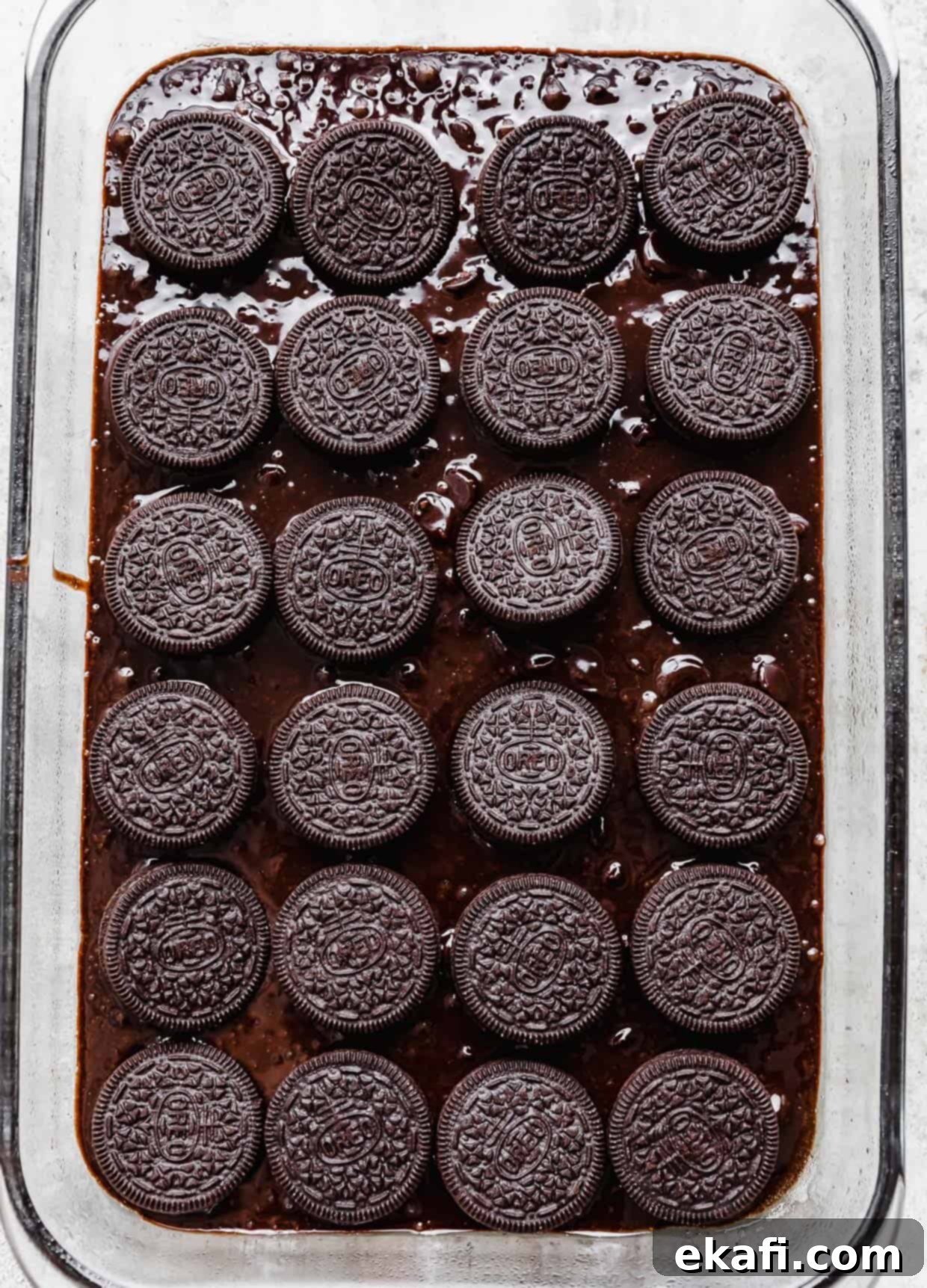 Ultimate Oreo Fudge Brownies 7 Whole oreo cookies placed on top of brownie batter in a glass rectangular baking pan.