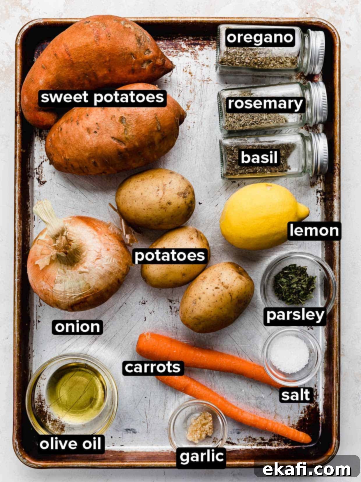 Easy Sheet Pan Root Roast 3 A sheet pan with ingredients used to make roasted root vegetables: sweet potato, potatoes, onion, carrots, and seasonings.
