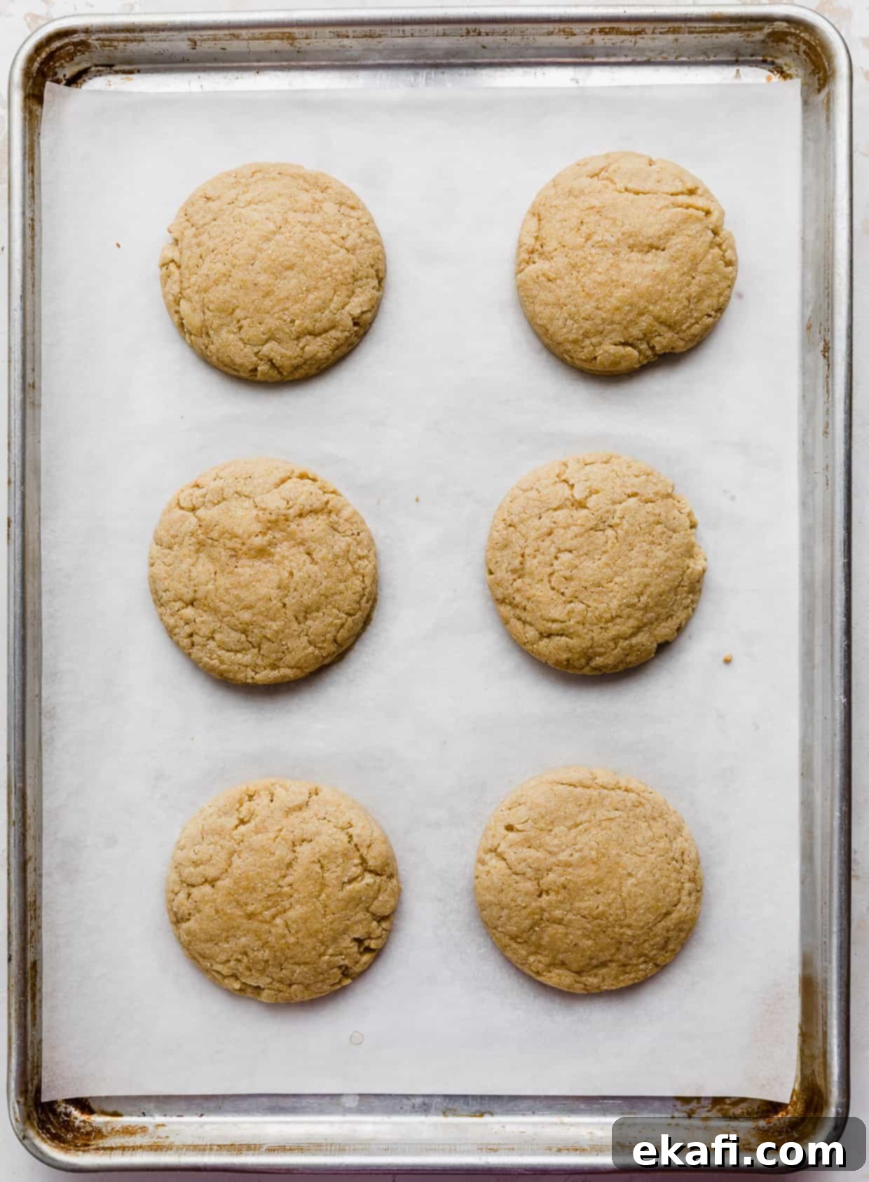 Crumbl Καλαμποκένιο Μπισκότο 6 Έξι ψημένα Crumbl cornbread cookies σε ένα ταψί, έτοιμα για διακόσμηση.