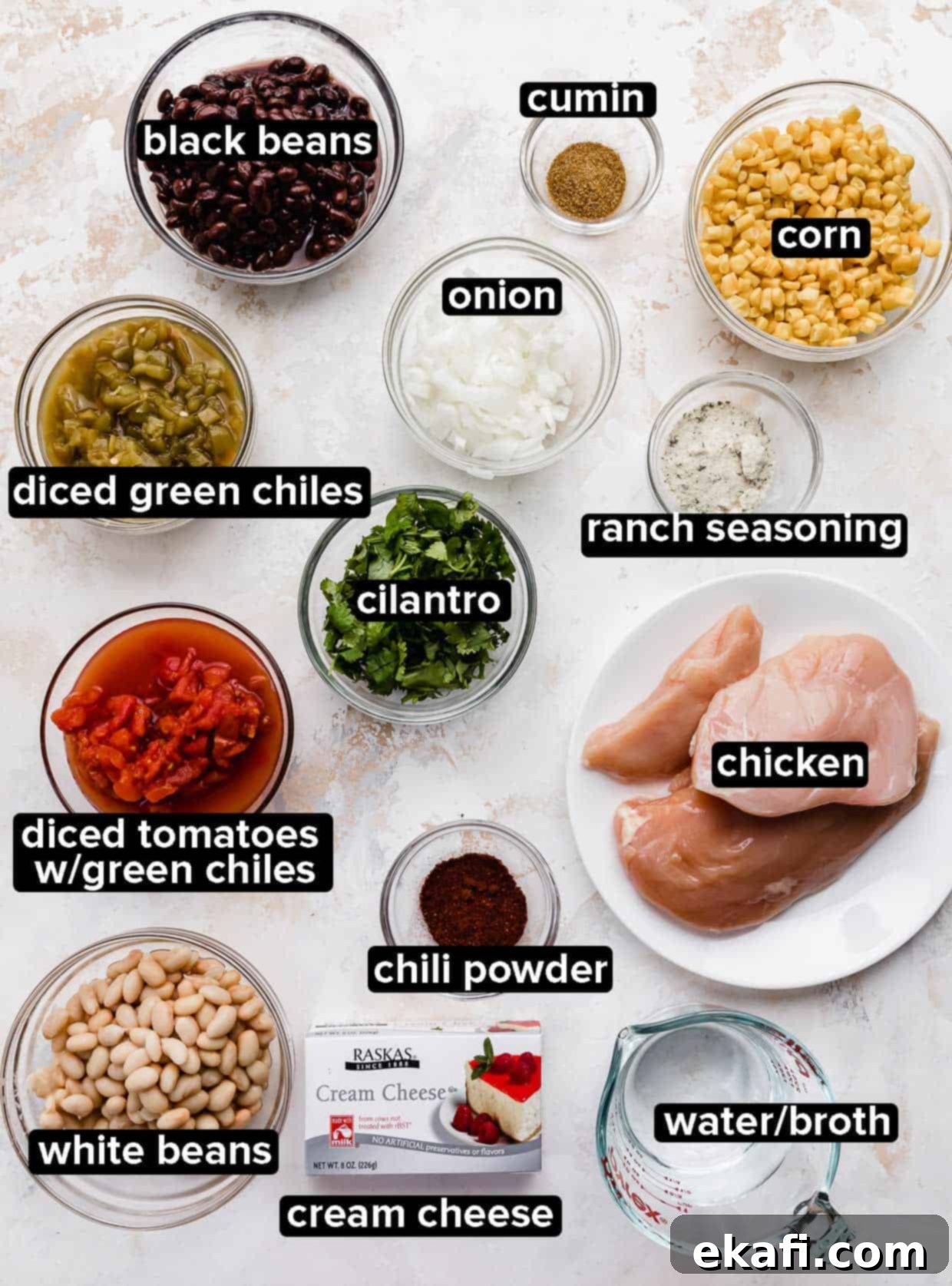 Dreamy Cream Cheese Chicken Chili 3 Crock Pot Cream Cheese Chicken Chili ingredients portioned into glass bowls on a white background, showcasing fresh cilantro, beans, corn, and cream cheese.