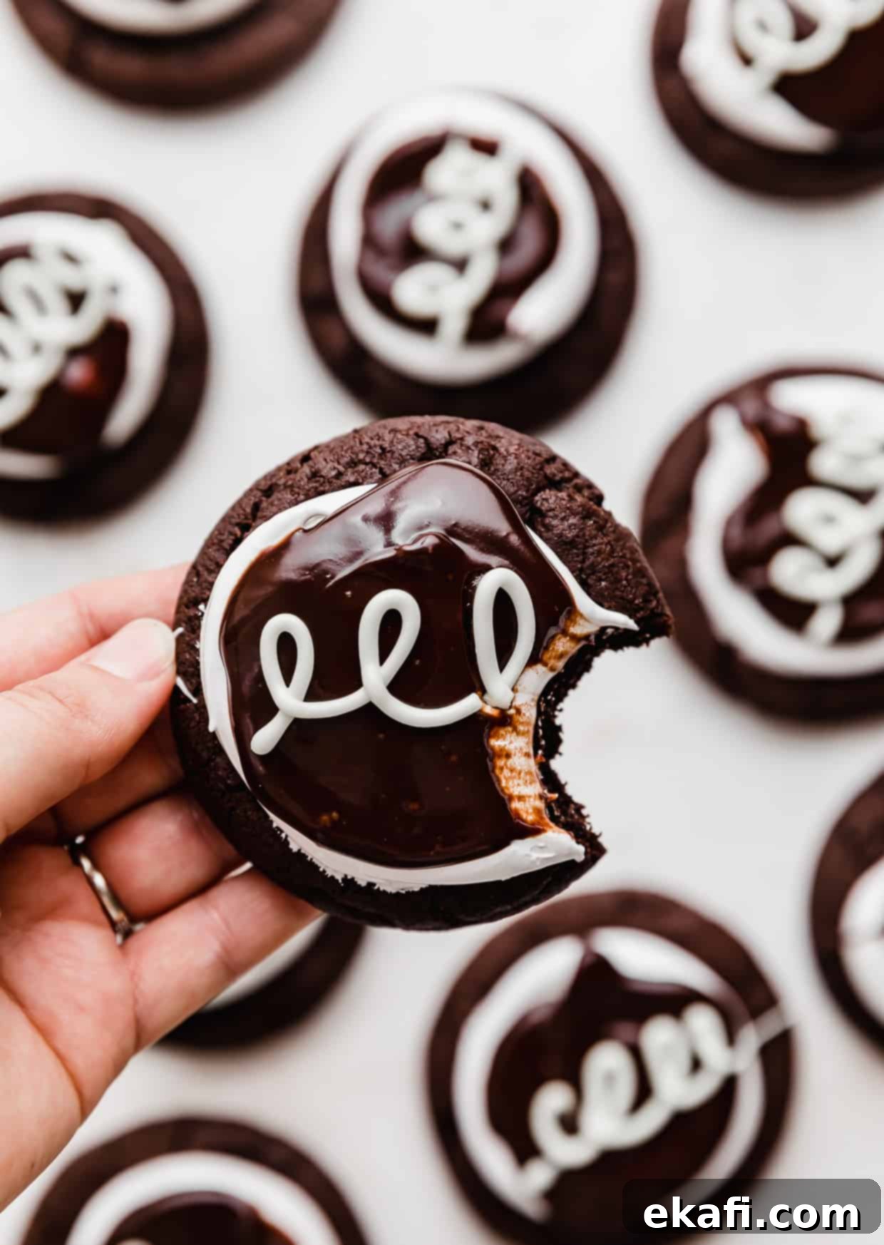 Hostess Cupcake Cookies 10 A hand gracefully holding a perfectly made Hostess Cupcake Cookie, showcasing its irresistible layers of chocolate, marshmallow, and ganache, ready to be devoured.