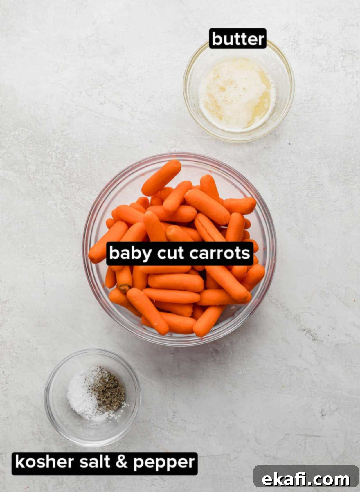 Caramelized Baby Carrots 3 A white background with baby carrots in a glass bowl, butter, and salt and pepper.
