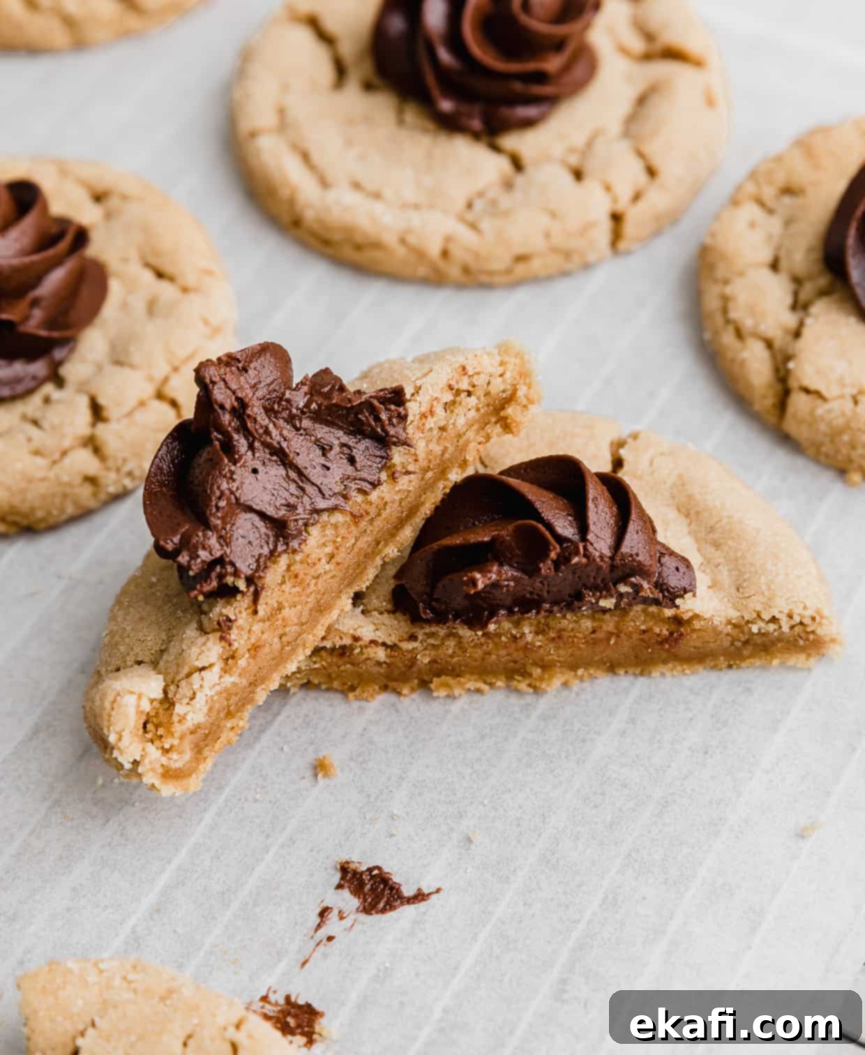 Crumbl Peanut Butter Blossoms 10 A Crumbl Peanut Butter Blossom Cookie cut int half on a white parchment paper.