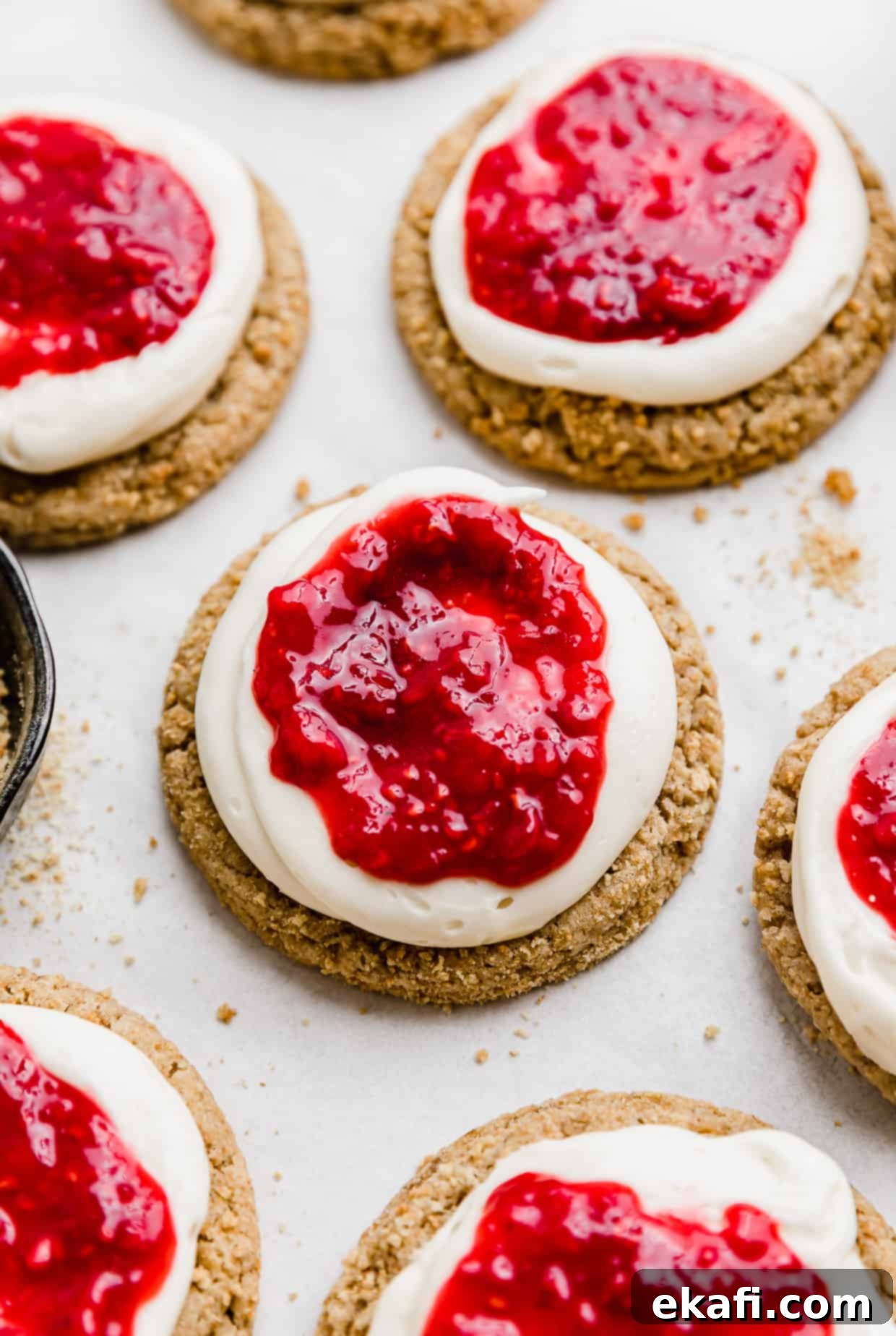 Creamy Raspberry Cheesecake Cookies 8 A graham cracker cookie topped with cream cheese frosting and a raspberry sauce.