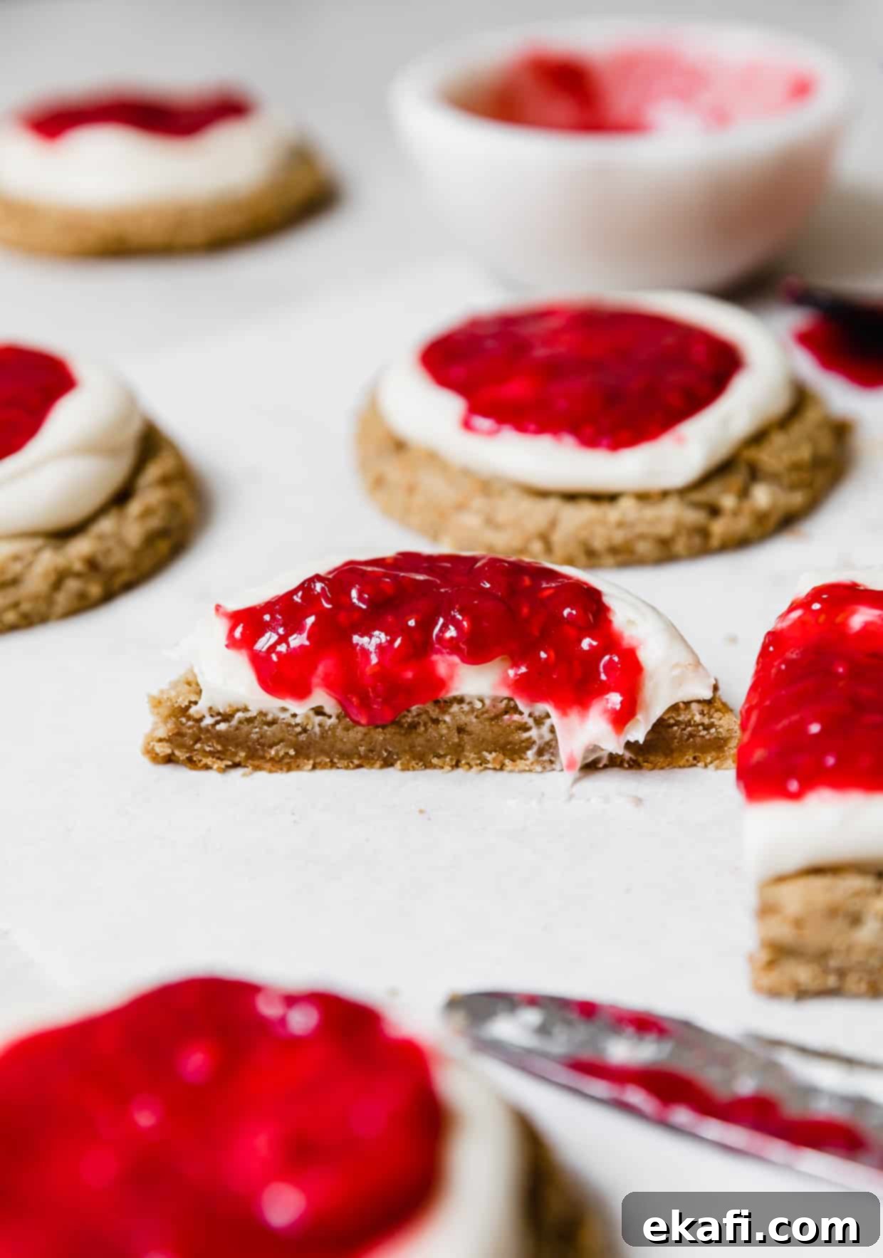 Creamy Raspberry Cheesecake Cookies 10 A Raspberry Cheesecake Cookie cut in half on a white table.