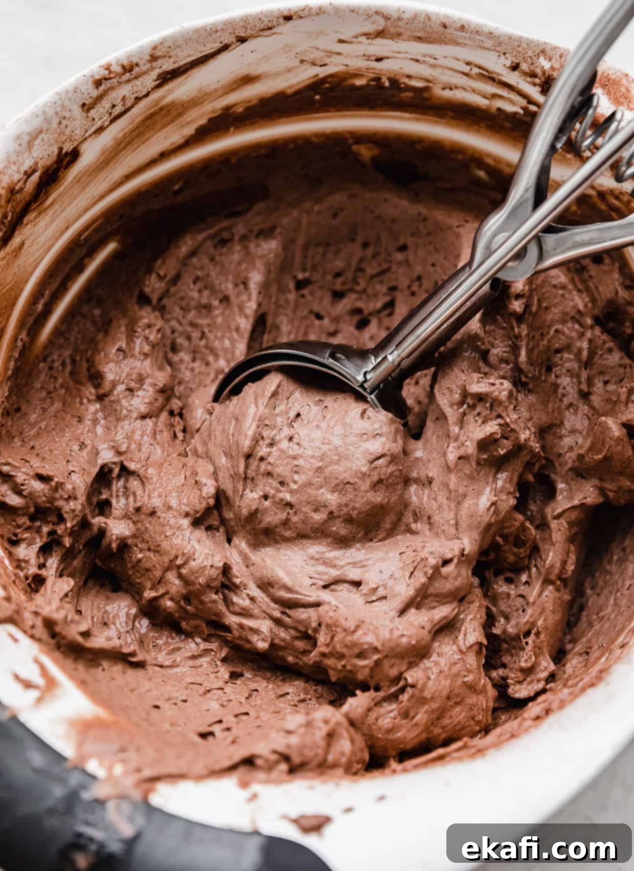 Decadent French Silk Pie Cookies 7 Crumbl homemade chocolate mousse filling used in French Silk Pie Cookies, in a bowl with a cookie scooper scooping out the mousse.