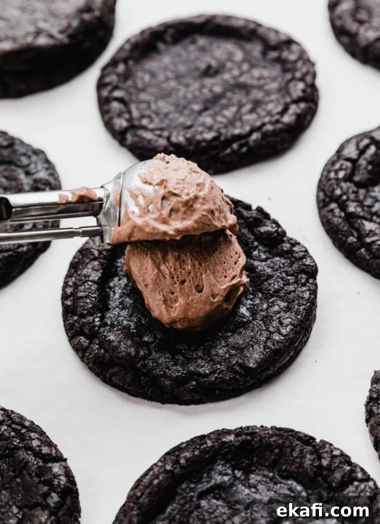 Decadent French Silk Pie Cookies 8 A cookie scoop putting chocolate mousse on top of a black cookie.