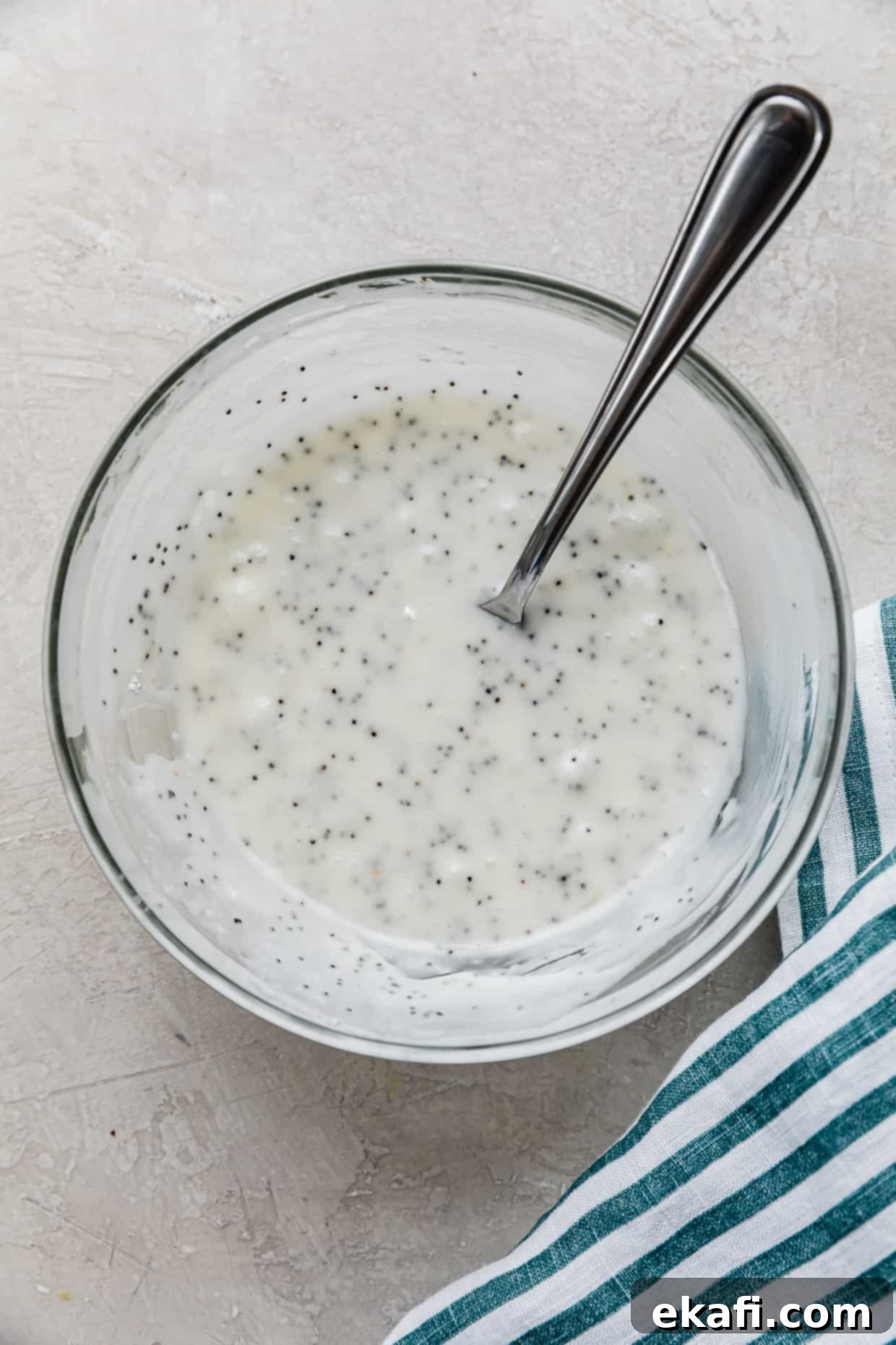 Zesty Lemon Poppy Seed Delights 11 A white lemon poppy seed glaze in a glass bowl.