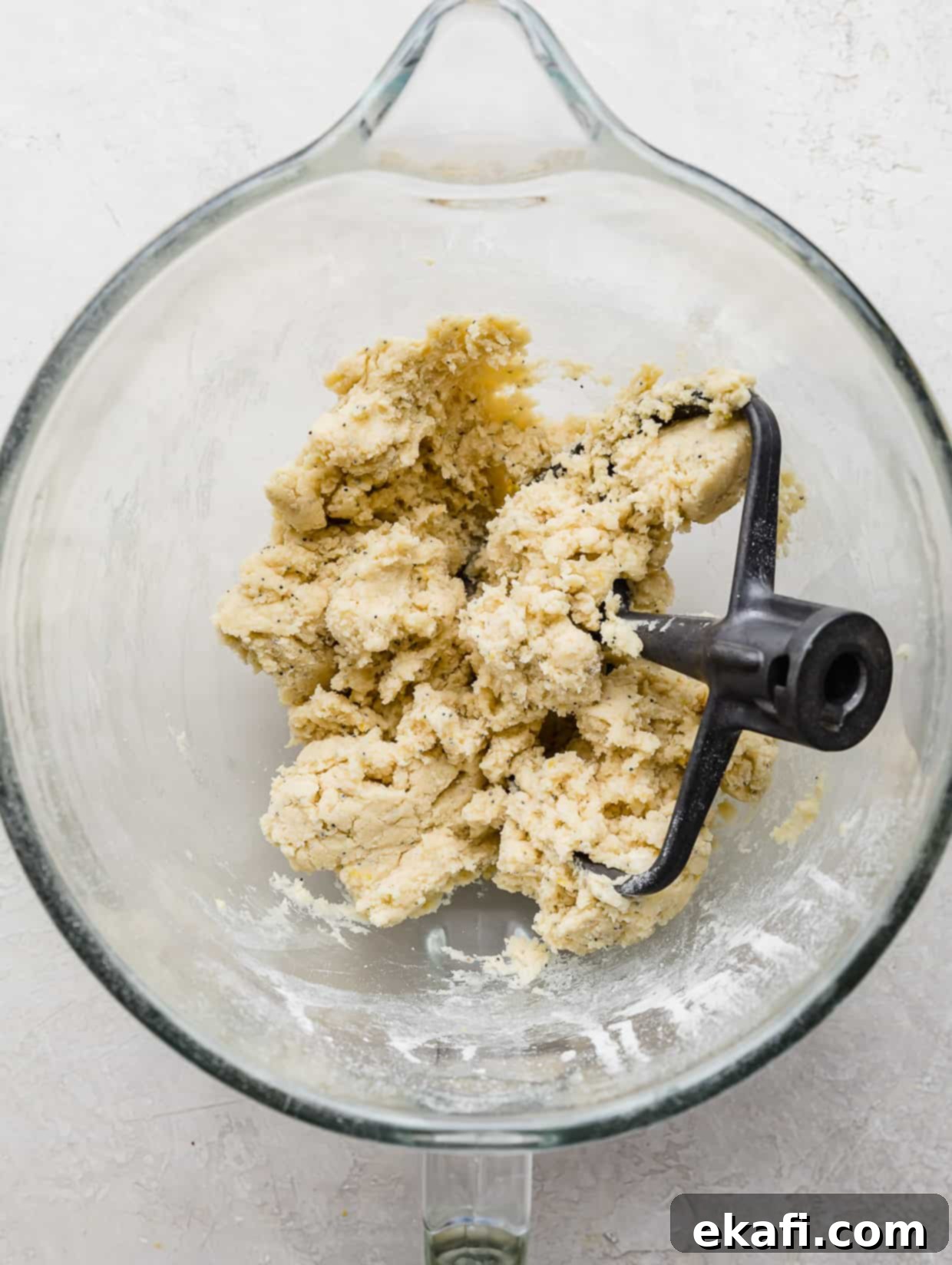 Zesty Lemon Poppy Seed Delights 6 Lemon Poppy Seed Cookie dough in a glass bowl on a white background.
