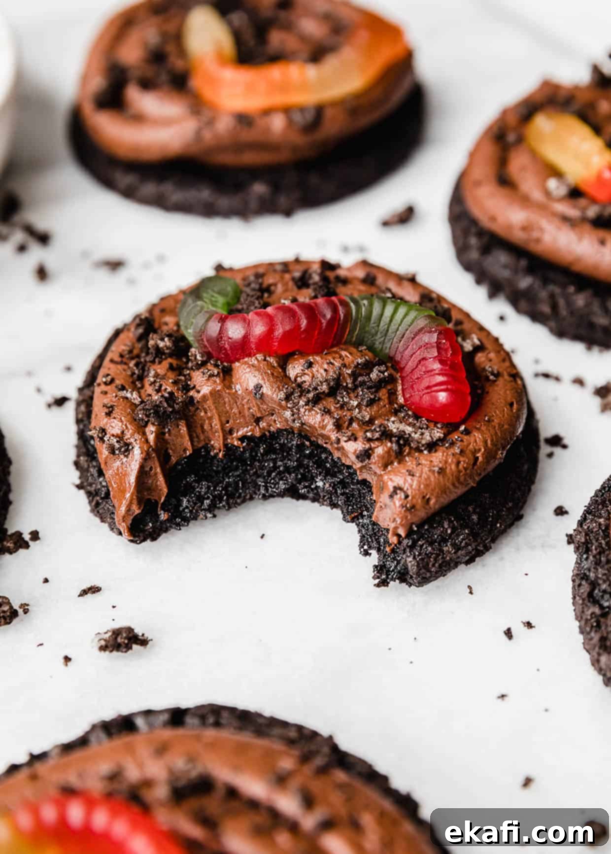 Oreo Mud Pie Cookies 2 A Dirt Cake Cookie topped with Oreo crumbs and gummy worm with a bite taken out of the cookie.